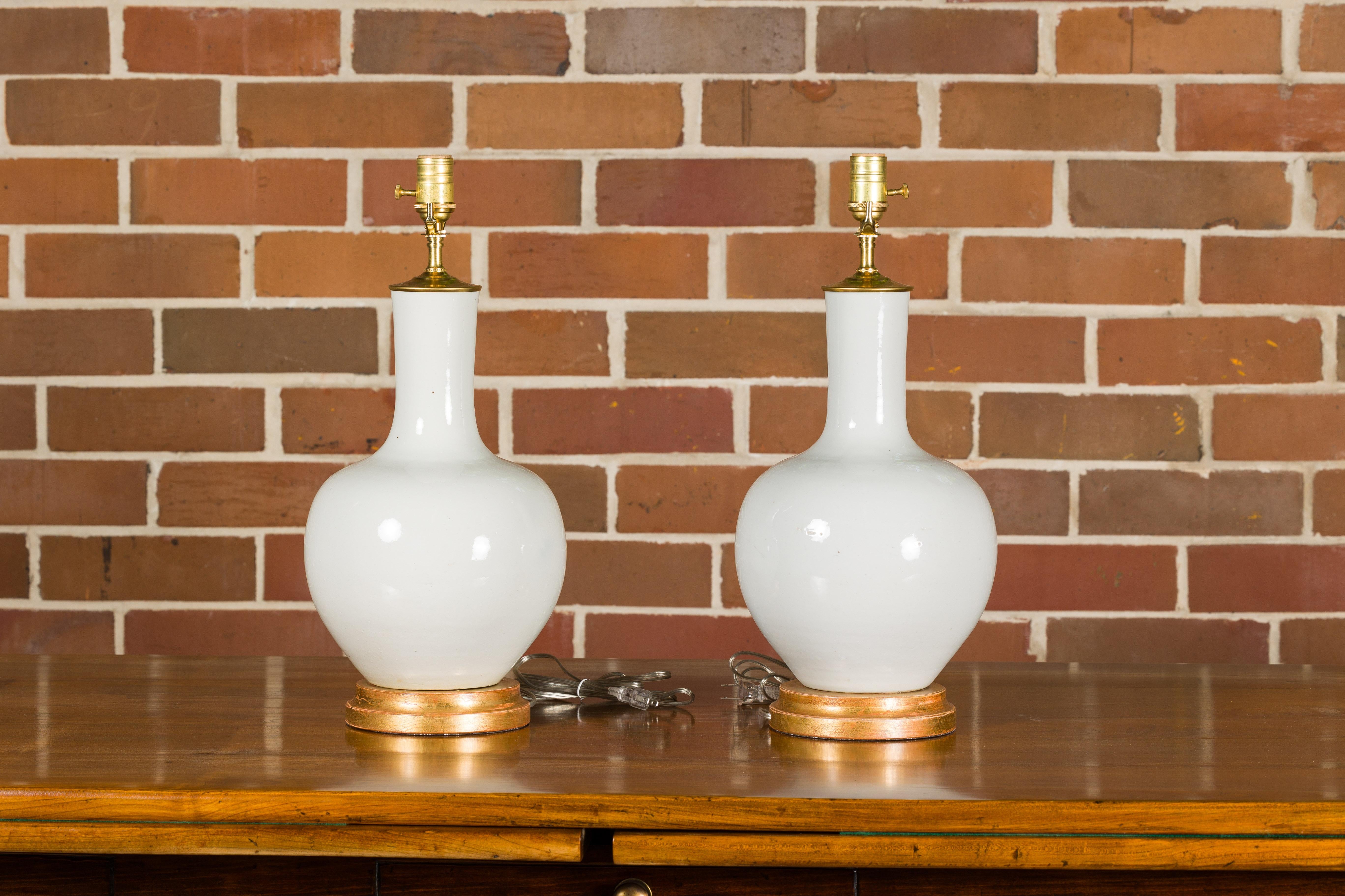 20th Century White Porcelain Vases Made into Wired Table Lamps on Giltwood Bases, a Pair