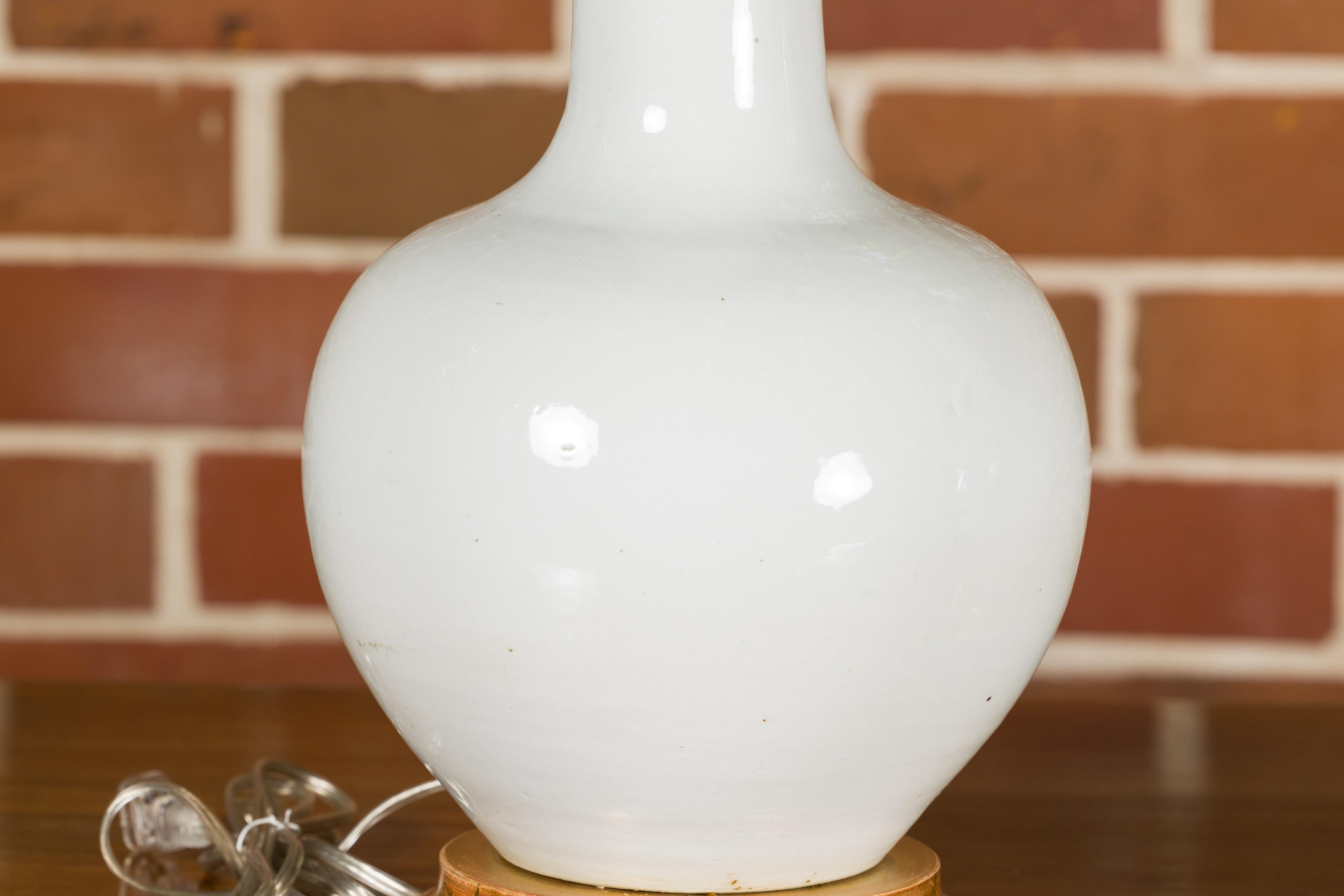 Paire de vases en porcelaine blanche transformés en lampes de table câblées sur bases en bois doré en vente 1