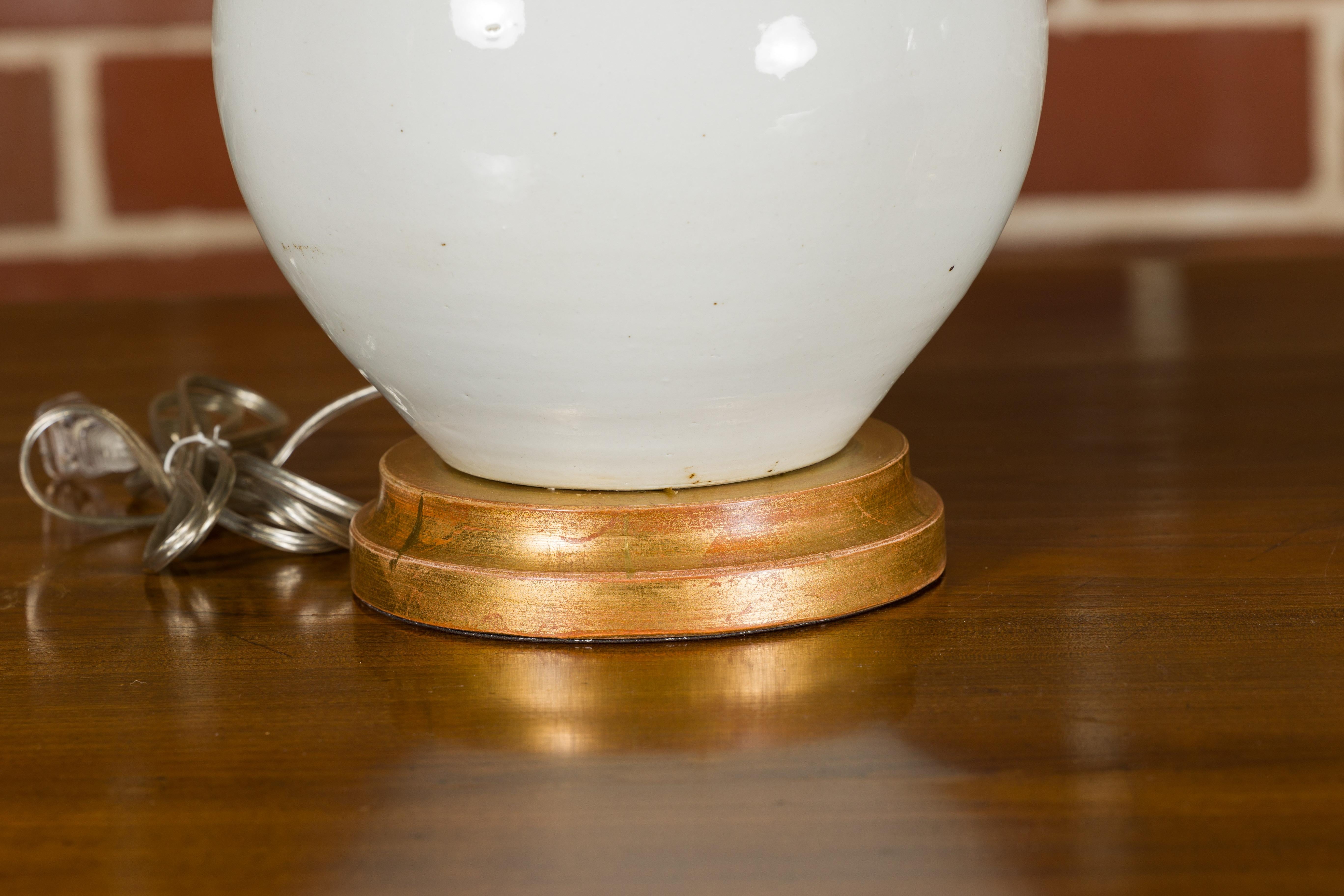 Paire de vases en porcelaine blanche transformés en lampes de table câblées sur bases en bois doré en vente 2