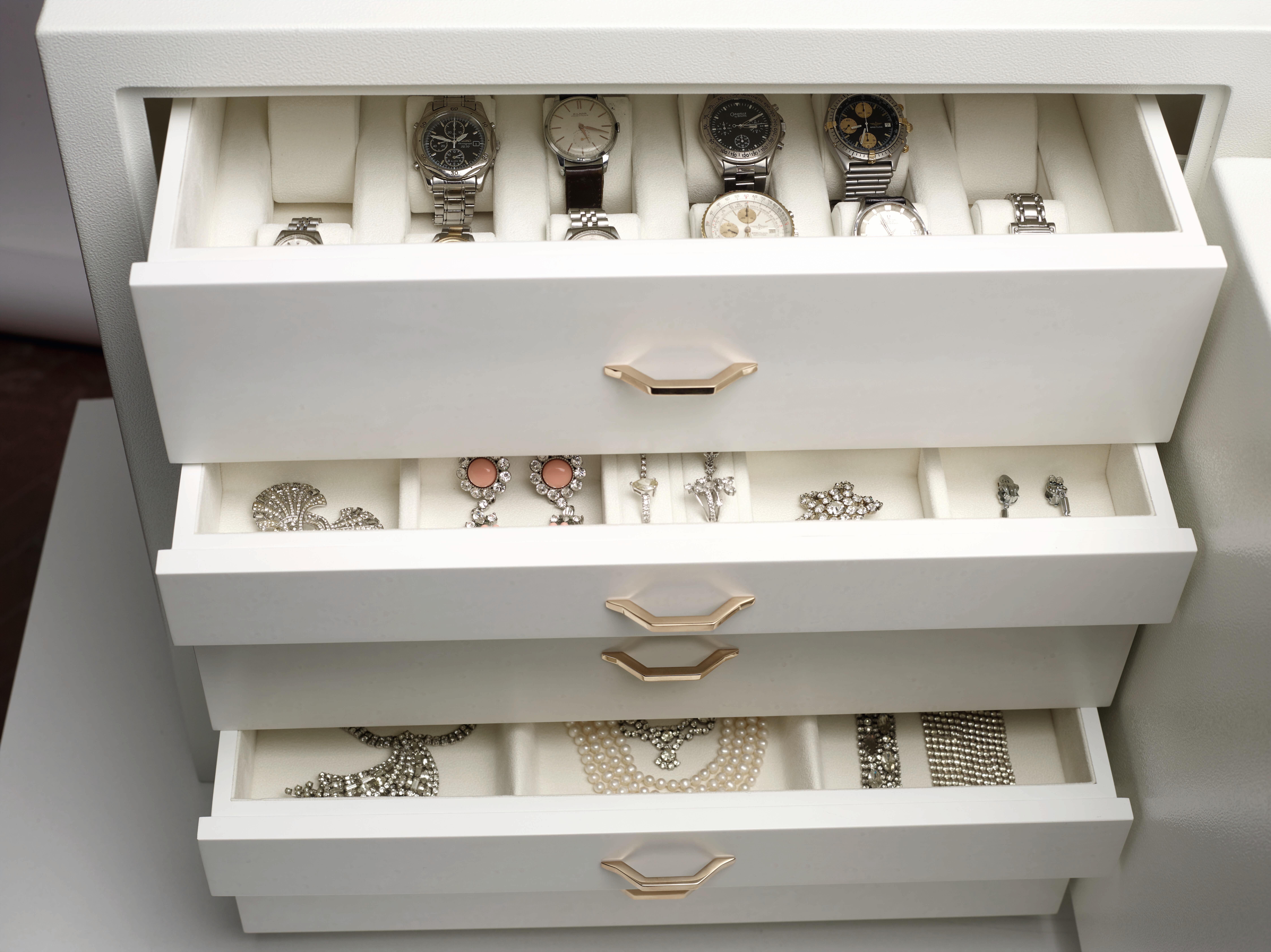 Sicher für Schmuck, erhältlich in drei Veredelungsvarianten. Einzelheiten zu den Veredelungsvarianten siehe unten. Kupfer: Schmuckkoffer aus gehämmertem kupferfarbenem Stahl. Schubladen in Mahagoni ausgekleidet für Schmuck und Uhren. Öffnung mit