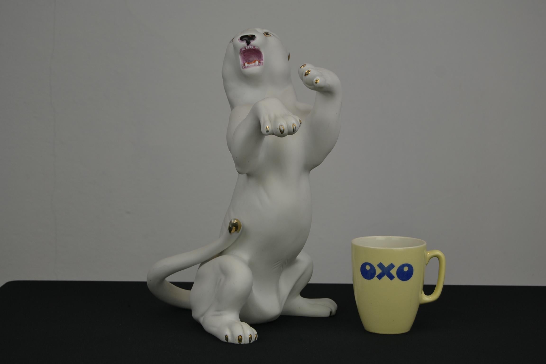 Biscuit Porcelain White Puma Sculpture. 
This White Puma Sculpture is very expressive and has hand-painted golden accents on the claws, ears and tale. It's a stylish detailed animal sculpture; look at the mouth, tongue and teeth. In good condition