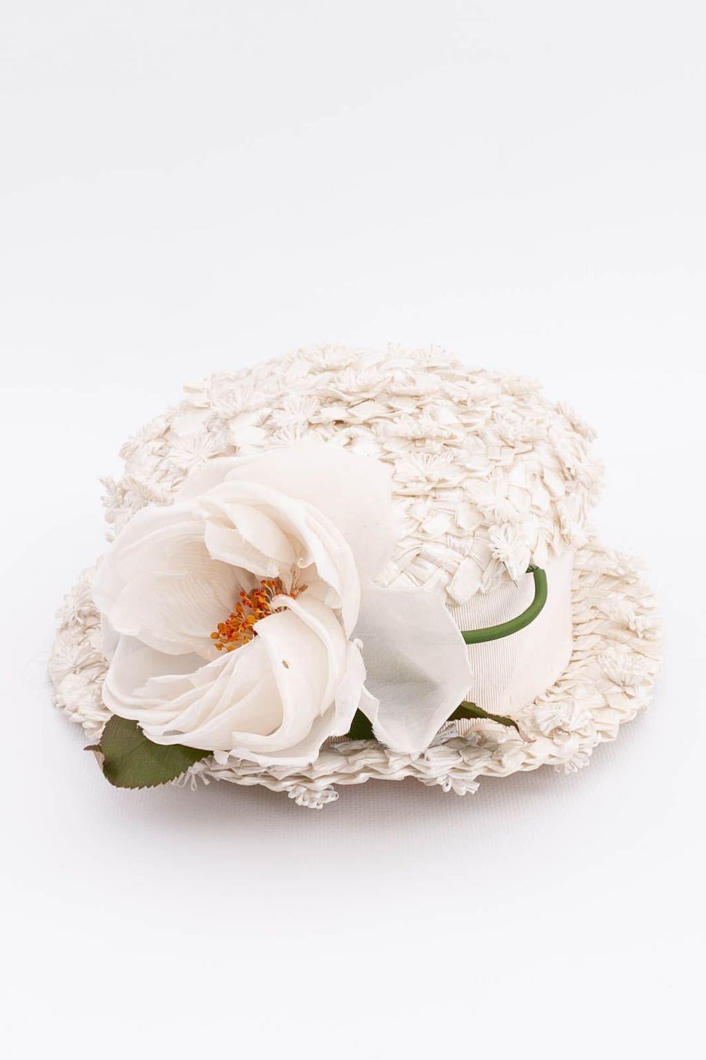 REGINE FRANCE - Cappello in rafia bianca decorato con un fiore in tessuto.

Condizioni:
Buono stato

Misure:
Circonferenza: 50 cm (19.68