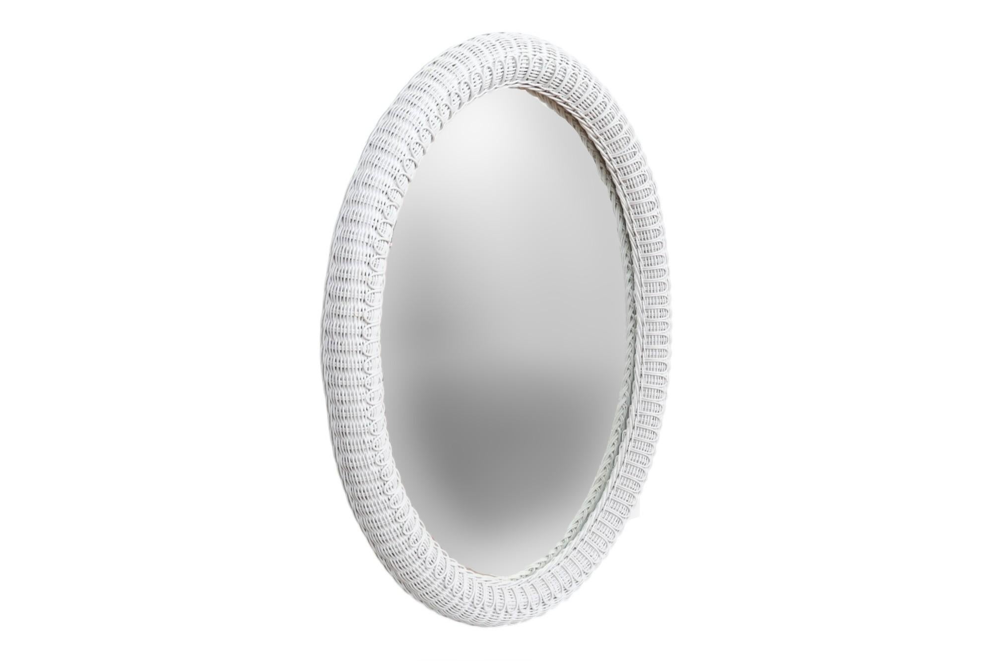Specchio da parete ovale attribuito a Henry Link. Il vimini bianco intrecciato in rattan è decorato con un motivo di petali di margherita intorno allo specchio. Sostenuto da una cornice in legno, con la scritta 