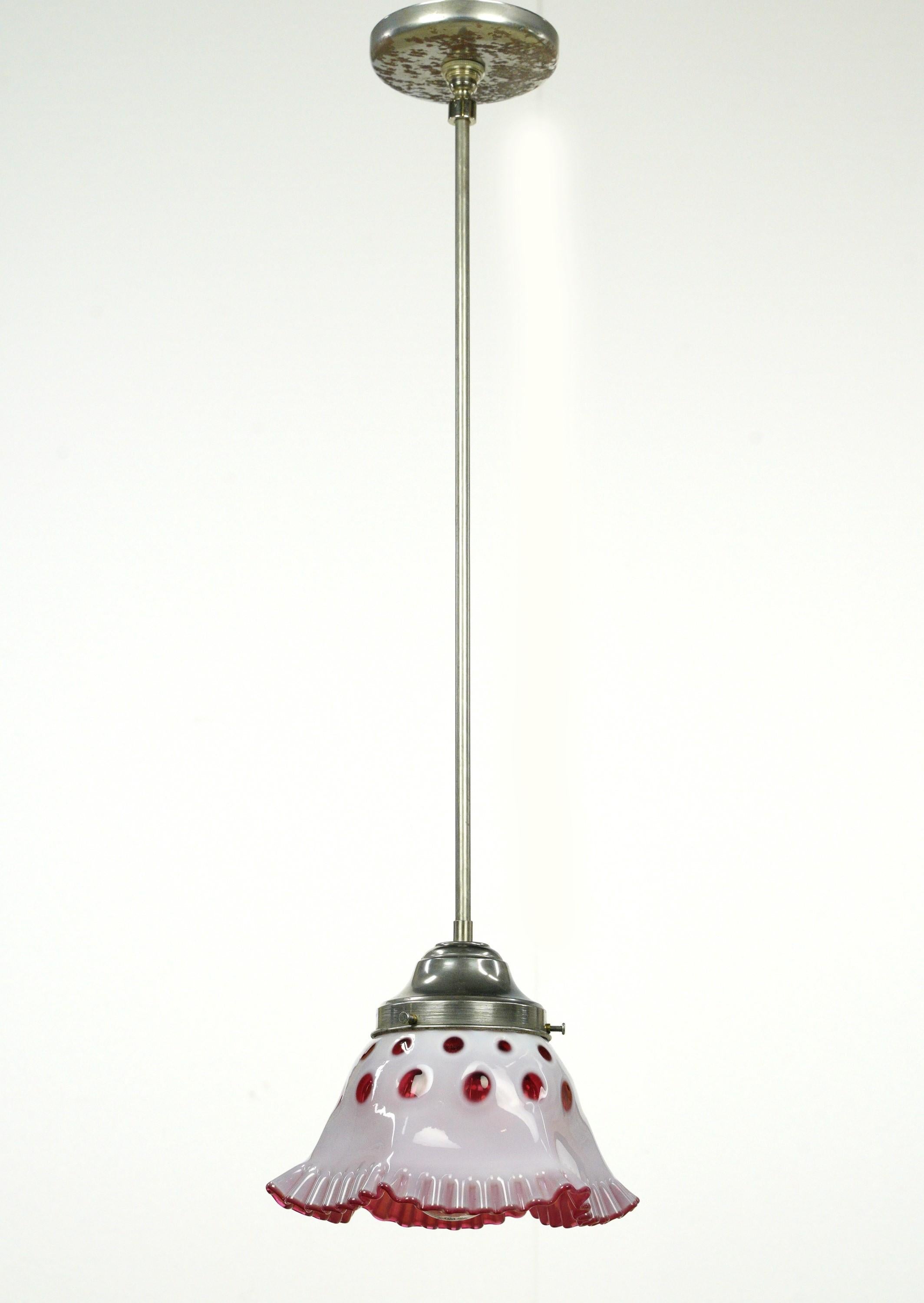 Petite red and white glass pendant light with steel hardware. This requires one standard medium base bulb. The price includes restoration of cleaning and rewiring. Comes with original hardware which can be upgraded upon request. Good condition with