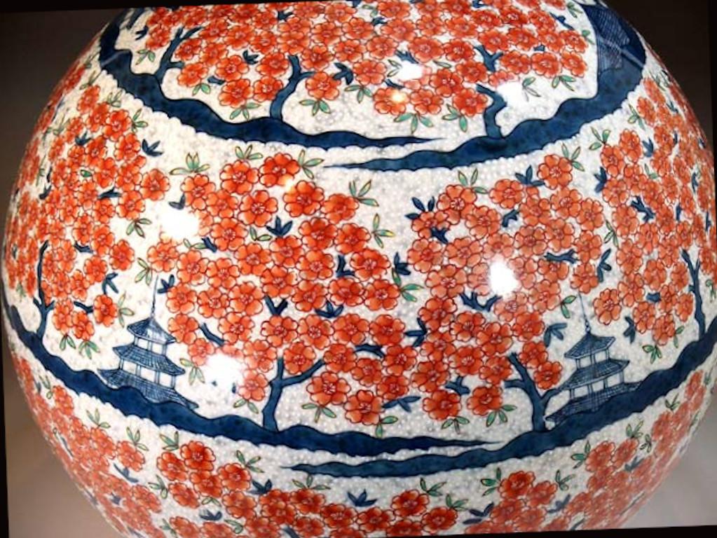 Exceptional gilded large contemporary Japanese Porcelain decorative vase, extremely intricately hand painted on a stunning ovoid shape body, depicting plum blossoms in red and medieval palaces in shades of blue on an elegant textured white
