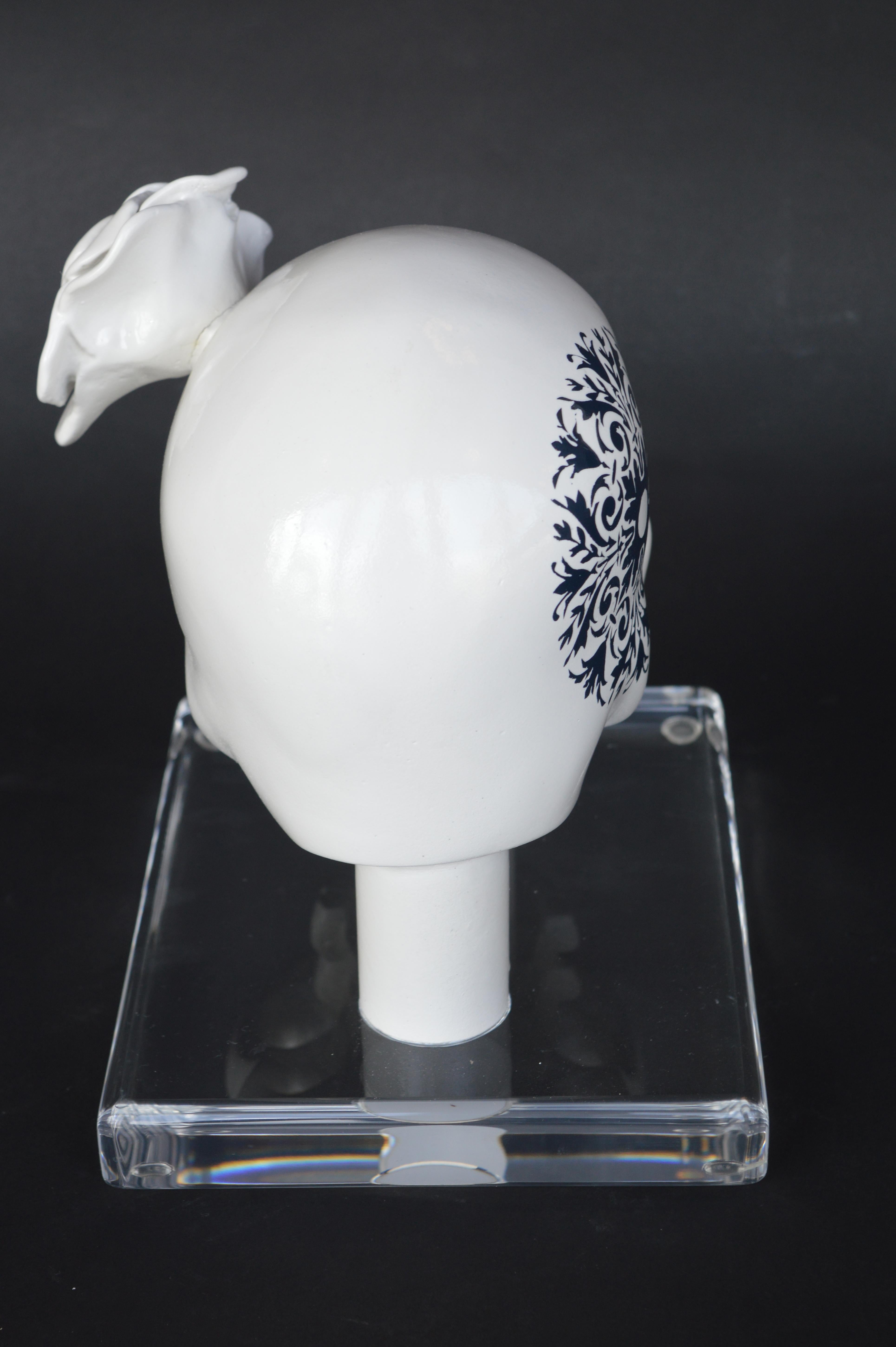 Decorative white resin skull on acrylic base.