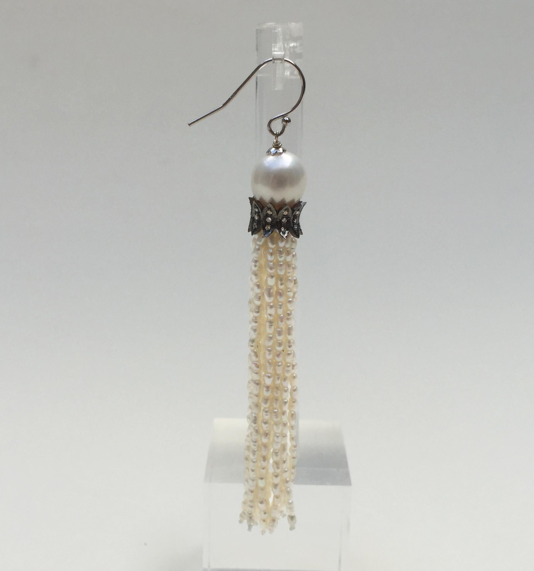 These white rice pearl tassel earrings with diamonds and 14k white gold hooks are elegant. Handmade by Marina J., these tassel earrings start with a glowing white round pearl. Holding the tassel together is a stylized diamond encrusted roundel made