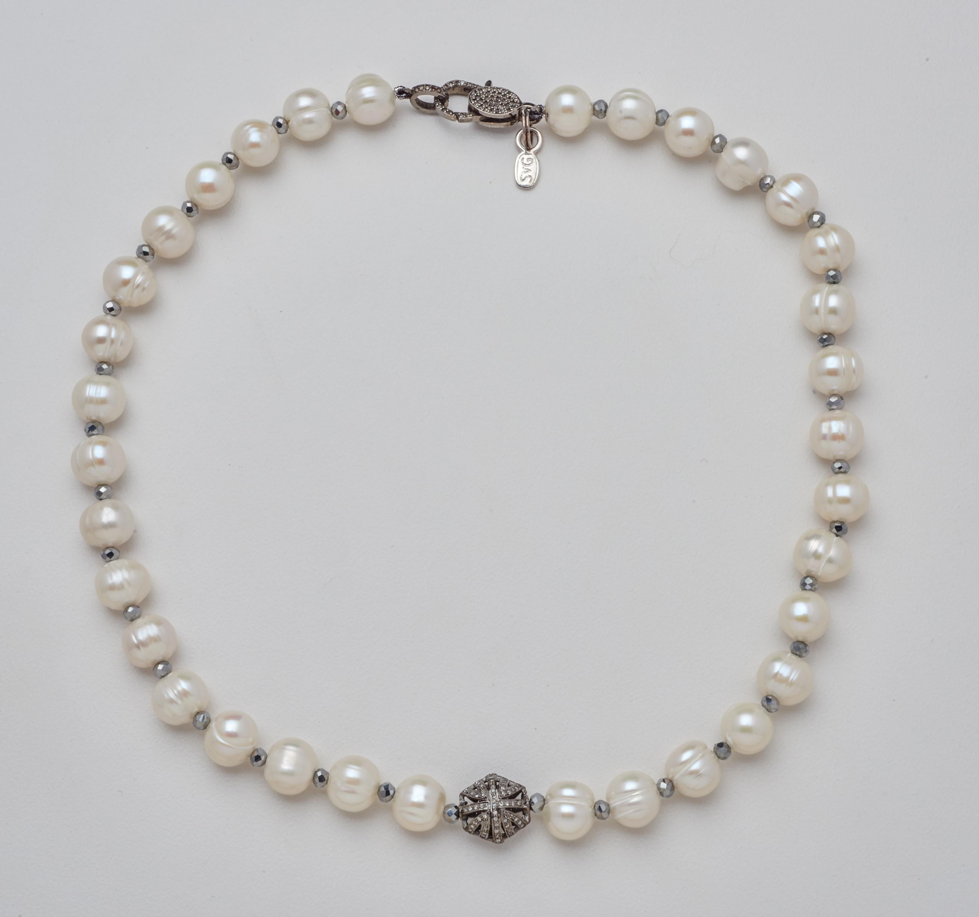 Thirty-four natural ringed White Akoya Pearls hand-strung with diamond-cut Hematite Beads lead to a stunning Diamond & Oxidized Sterling Silver Puff Bead Charm feature. This sixteen inch Necklace is finished with a Diamond and Sterling Silver Clasp.