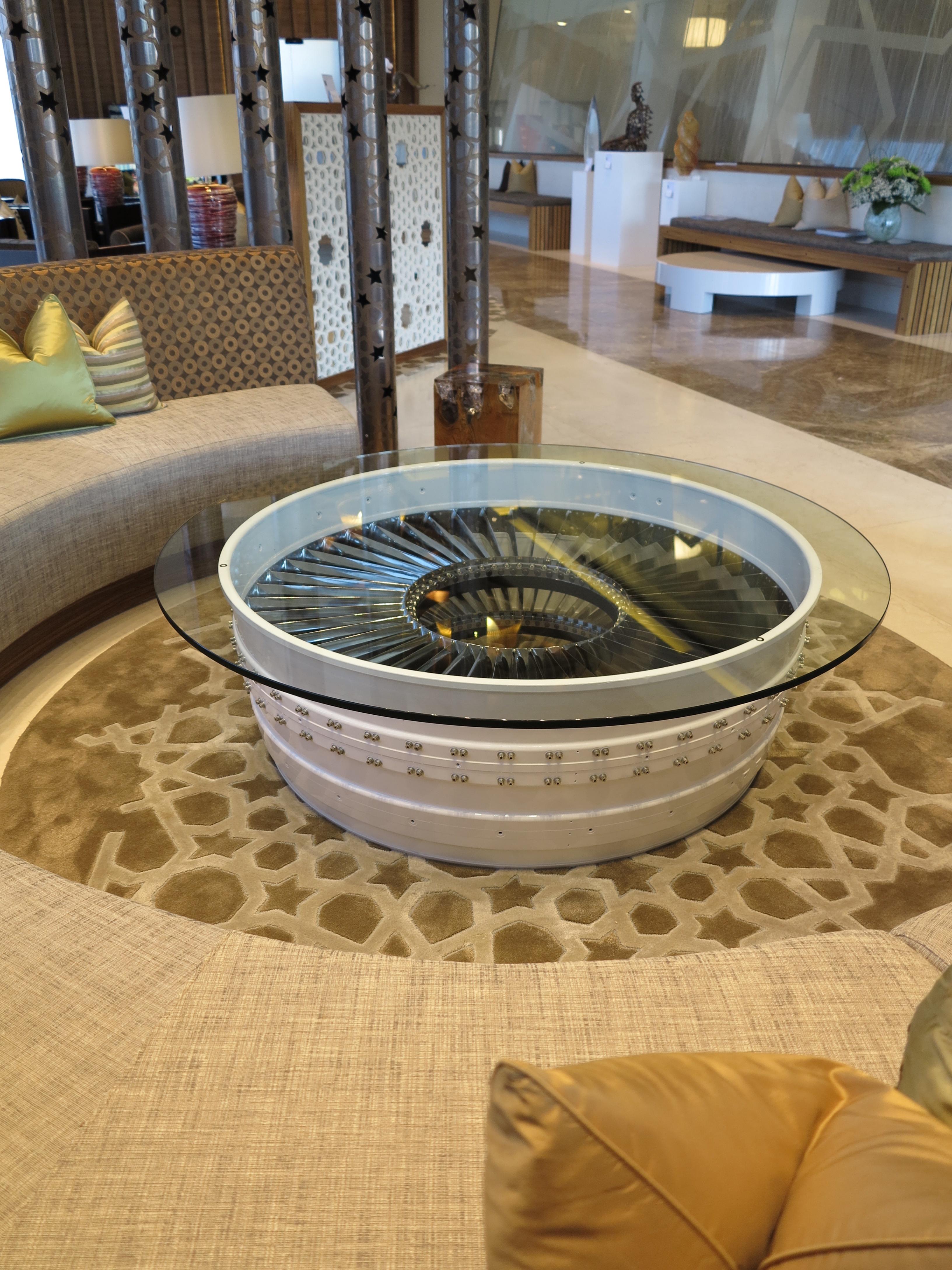 A simply stunning coffee table with two sets of polished titanium stator blades, underneath 15mm toughened glass, makes this practical and unique. 

The casing used in making this table is from a Rolls Royce Pegasus Sea Harrier FA2 Jump Jet
