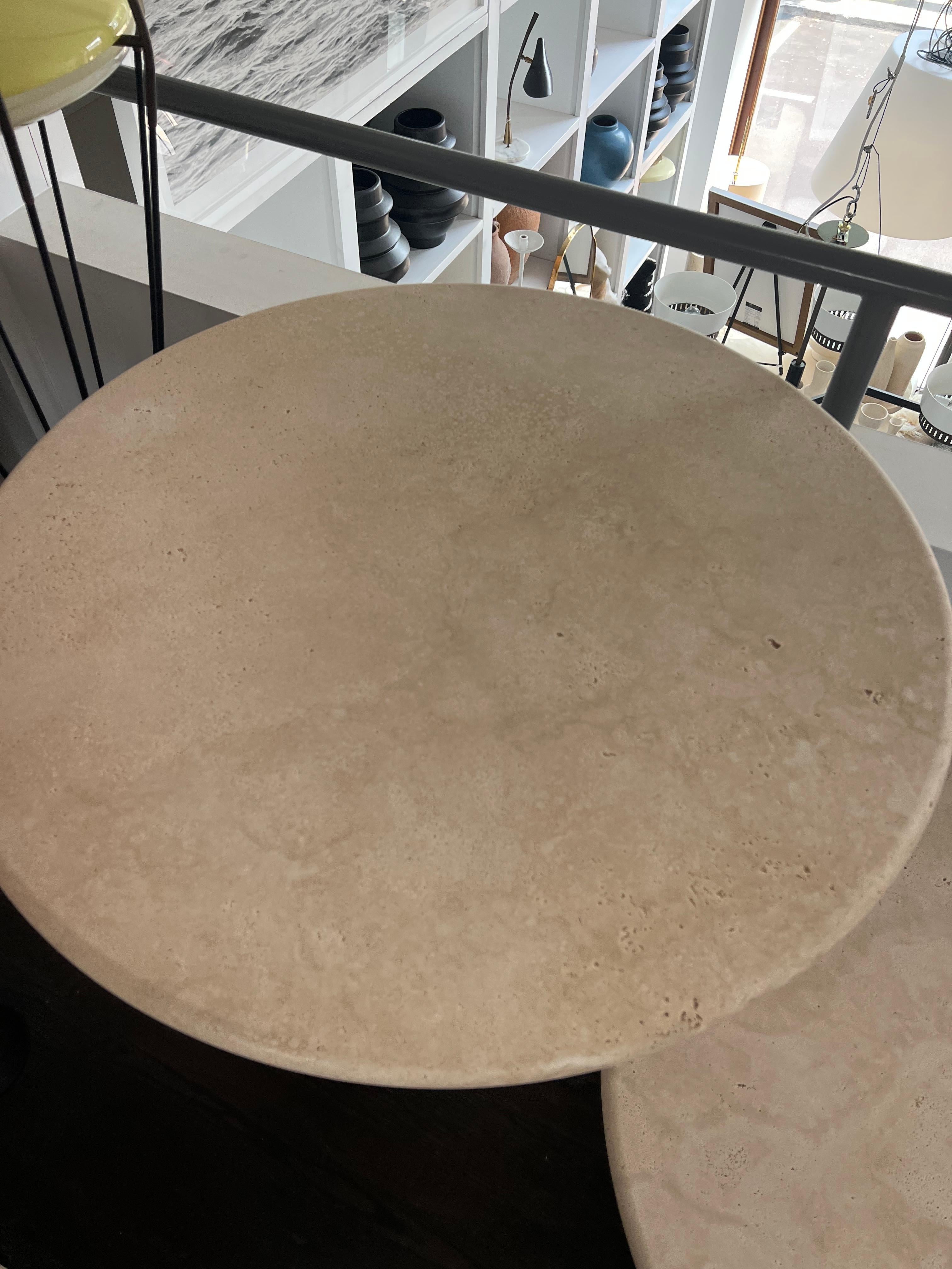 White Roman travertine table by Le Lampade. 
Round travertine top supported by a travertine column shaped base. These tables can be custom made. 29'' H X 35''.