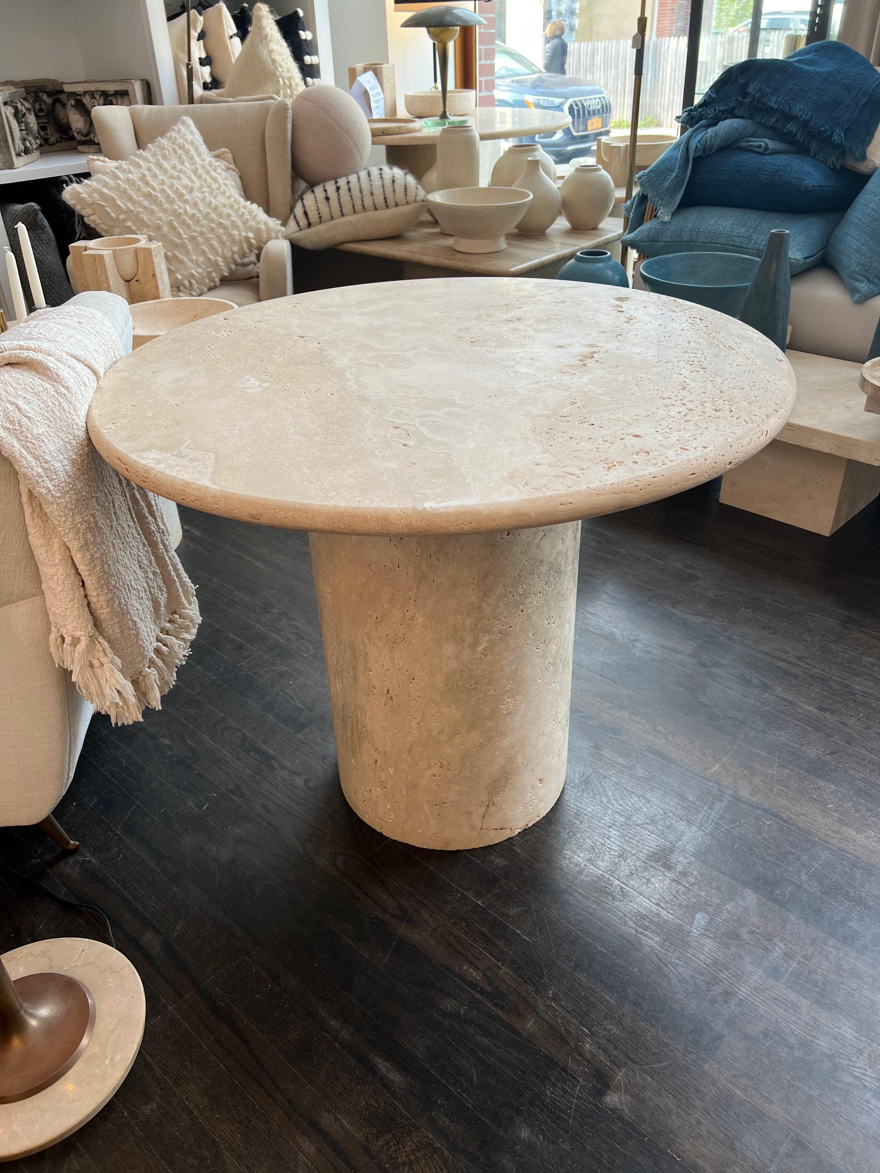 White Roman travertine bistro table by Le Lampade.
Round travertine top supported by a travertine column shaped base. These tables can be custom made.