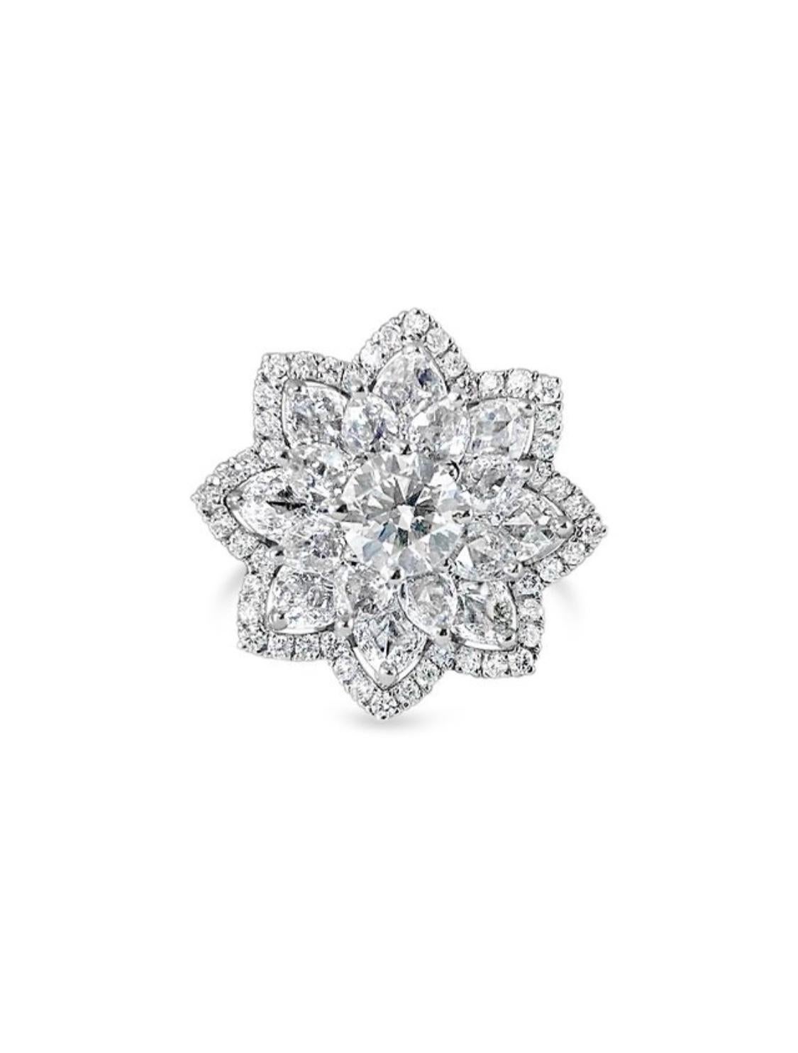 Il s'agit d'une magnifique bague florale comprenant un diamant rond brillant centré sur un lit à deux niveaux de diamants taillés en rose, réalisée à la main en or blanc 18 carats. 
Les détails sont les suivants : 
Poids total des diamants : 2,26