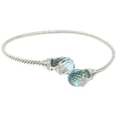 White Round Brilliant And Blue Topaz Flexible Bangle In 18K White Gold.