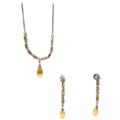 Pendentif trois pièces en or 18 carats serti d'un diamant rond brillant et d'une topaze blanche.