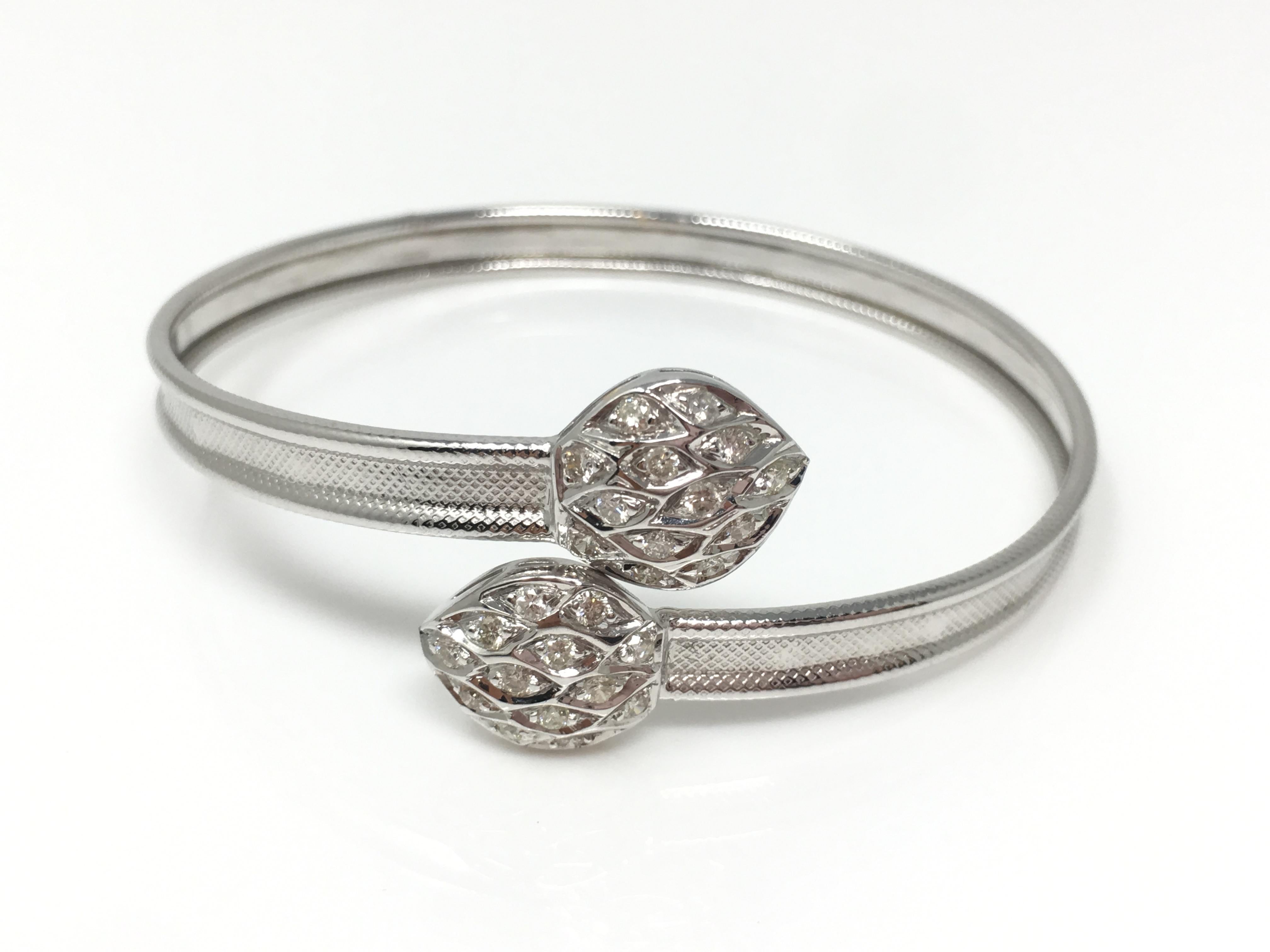 This elegant yet stylish diamond bangle is custom handmade in 18k white gold . The diamond weight is 0.60carat with GH color and VS clarity. The gold weight is 9.600 grams . The size is flexible and adaptable to most wrist sizes. 