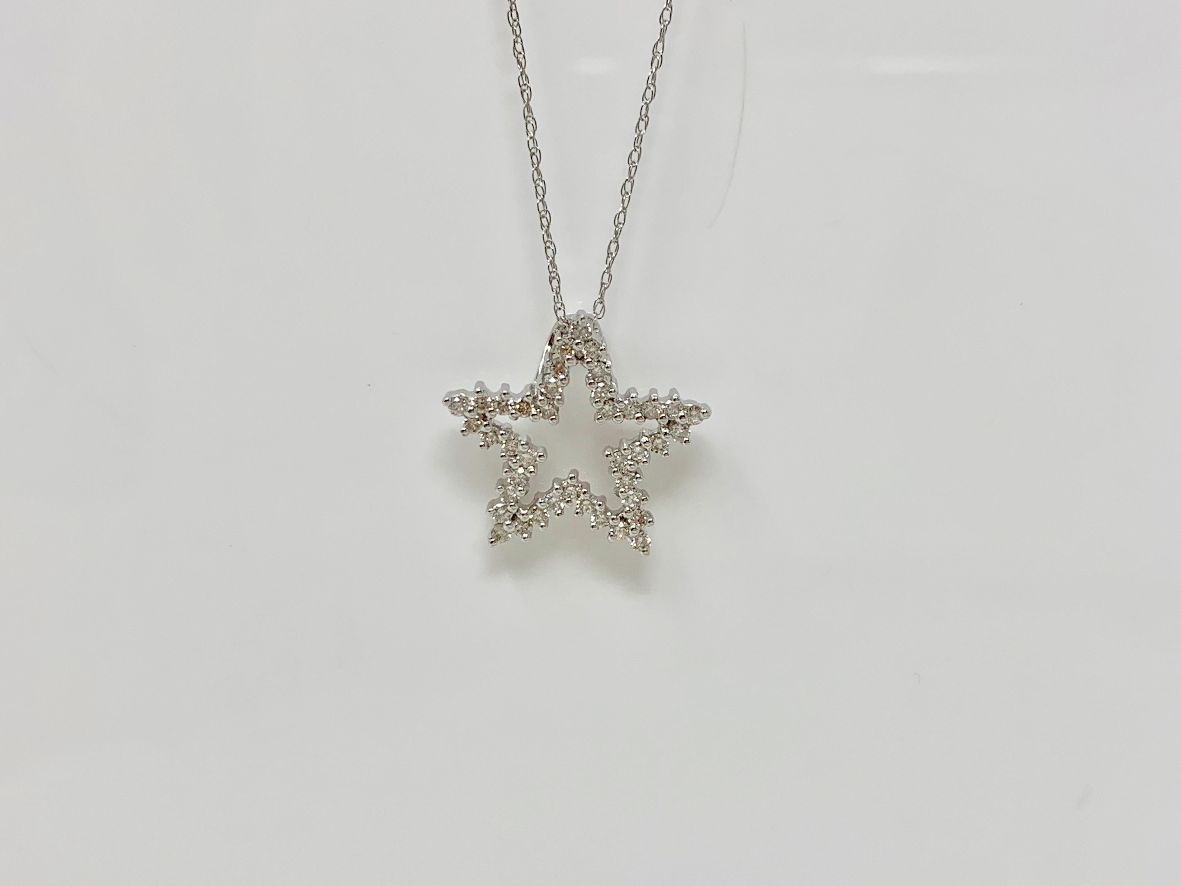 Questo ciondolo a forma di stella tonda e brillante è realizzato a mano in oro bianco 14 carati. Il peso del diamante è di 0,47 carati con colore HI e purezza SI.