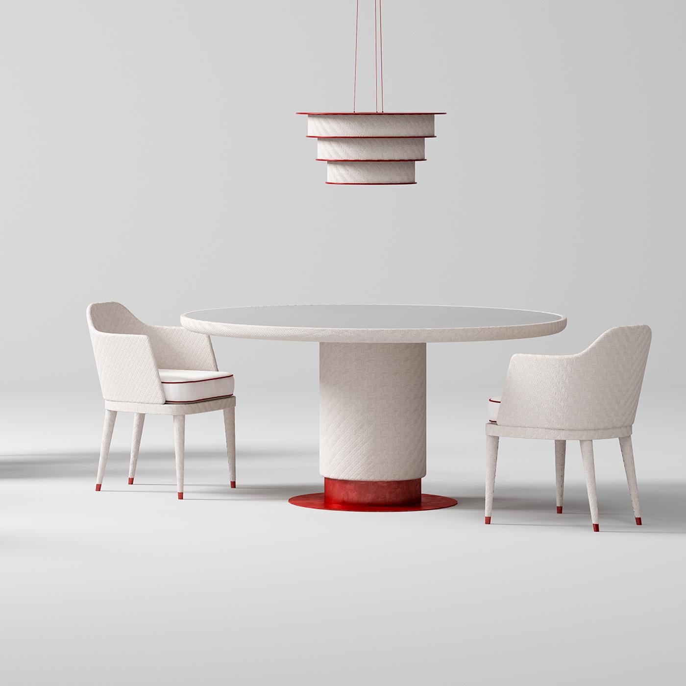 The monolithic and sculptural line of this stunning table is easily adaptable to outdoor spaces thanks to its elegant and resistant materials. Raised on a flat platform of galvanized iron polished and coated with red epoxy powder, the pedestal base