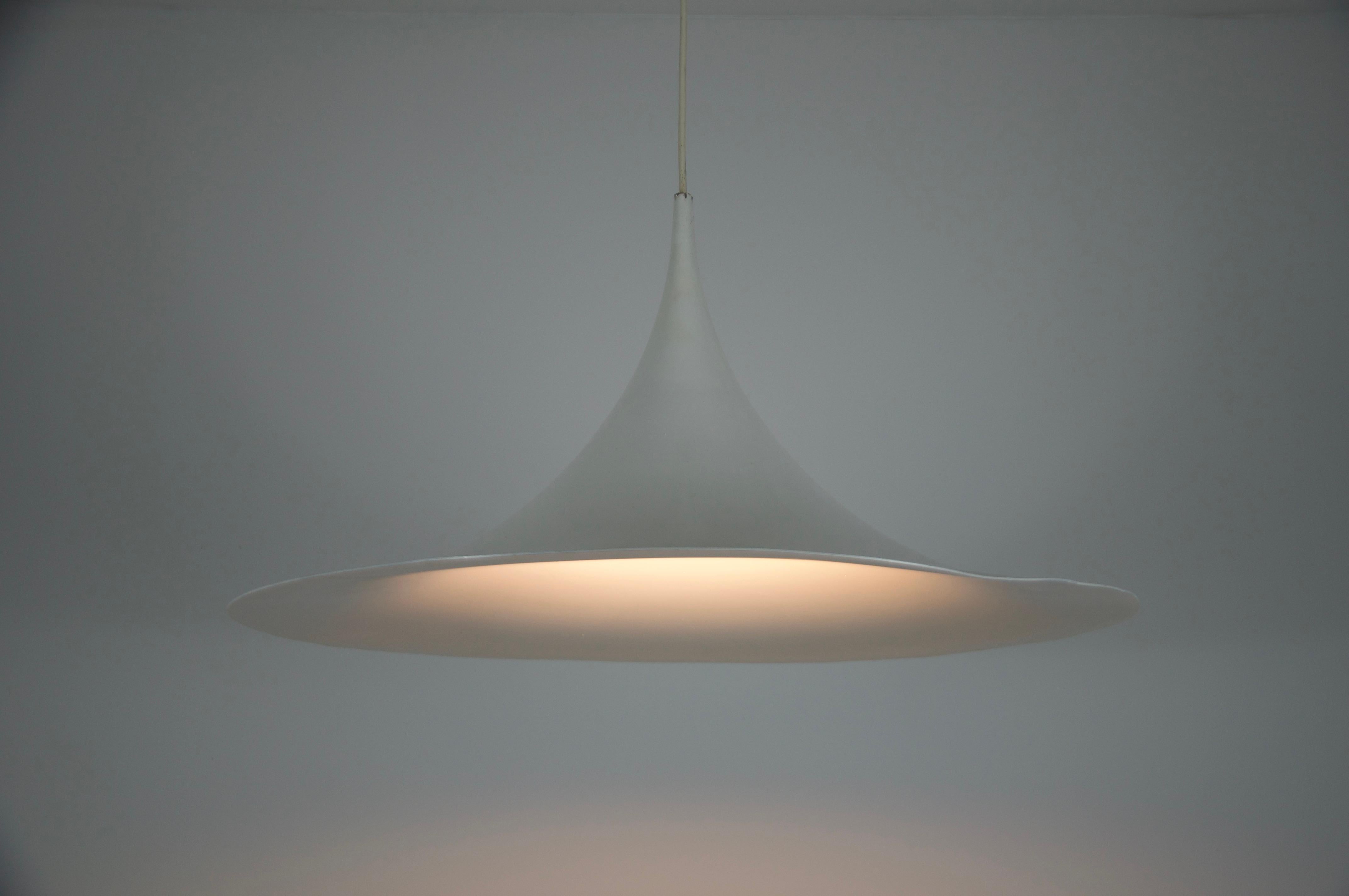Questa lampada a sospensione rotonda bianca di Fog & Mørup, realizzata in Danimarca negli anni '70, è un esempio lampante di design moderno scandinavo. La sua forma scultorea a imbuto confluisce in un ampio paralume circolare, creando una silhouette