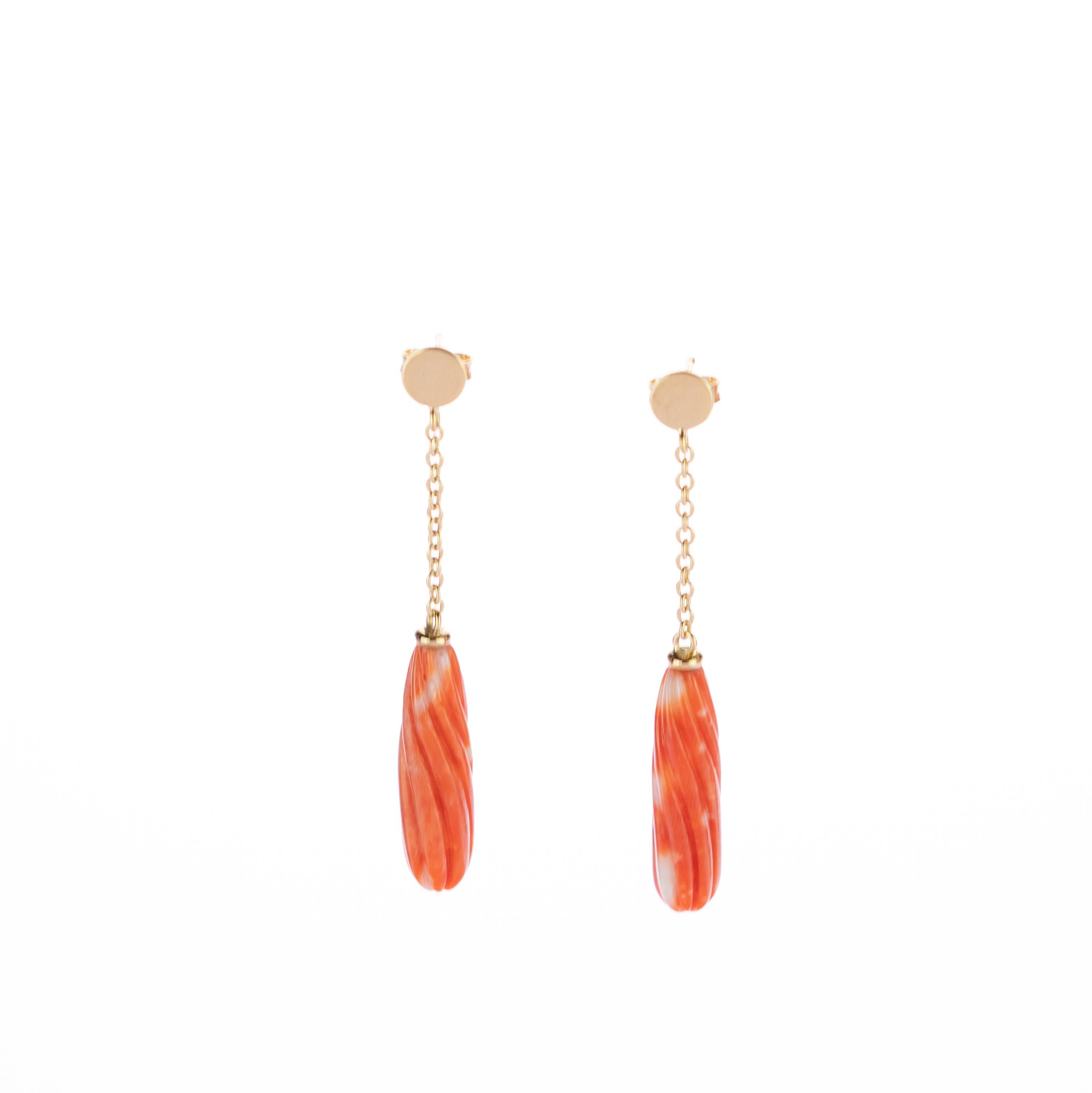 Magnificent and exotic coral  drop earrings design. The 18 karat yellow gold enhances the dangle piece with a round circle that is connected to a delicate chain holding a beautifully carved white and salmon natural coral long shaped gem. Italians