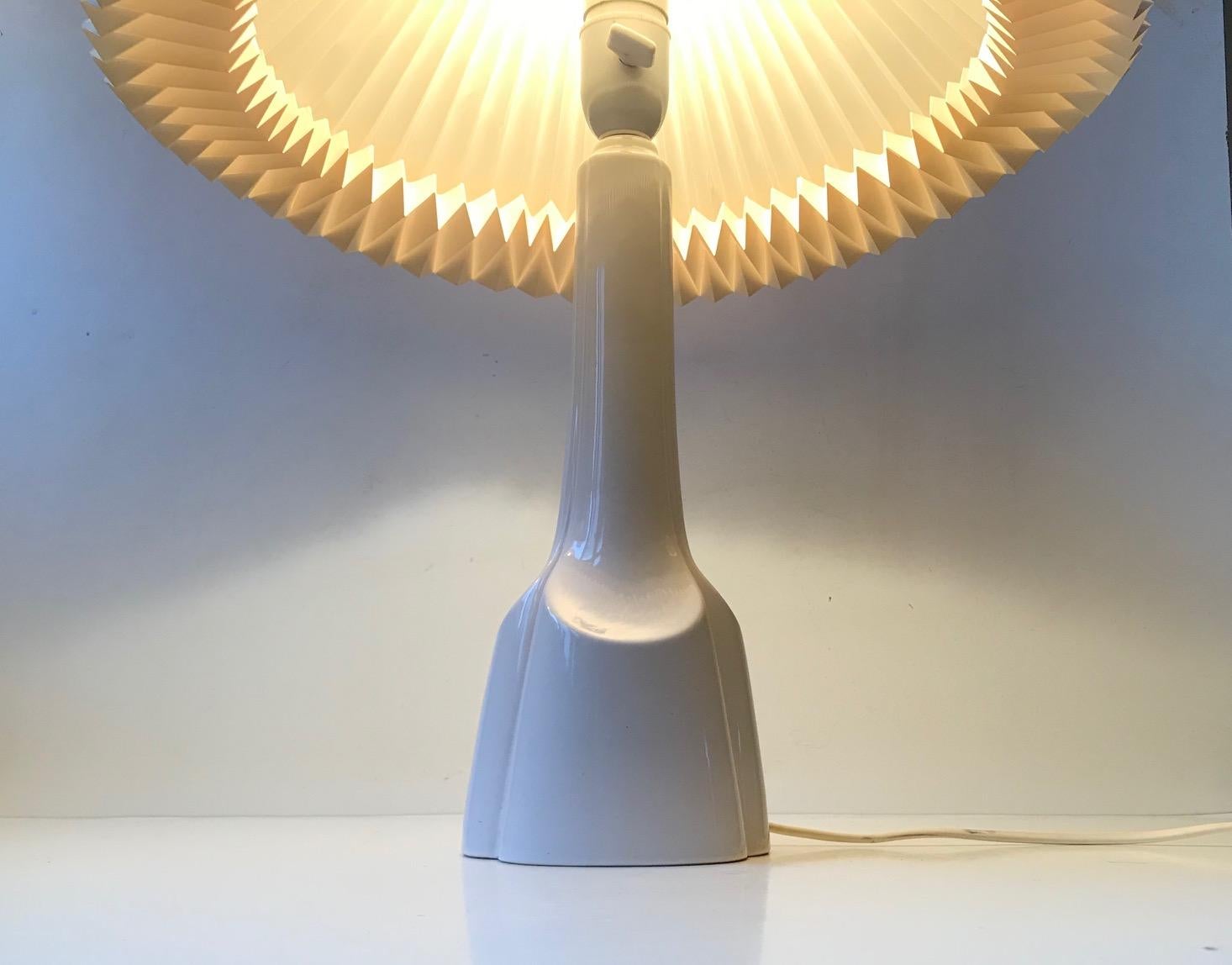 Lampada da tavolo in ceramica danese con smalto bianco dens. Forma architettonica stilizzata con linee morbide ed equilibrate. Questo esemplare in particolare è stato prodotto da Søholm in Danimarca negli anni '70. È dotato della sua presa originale