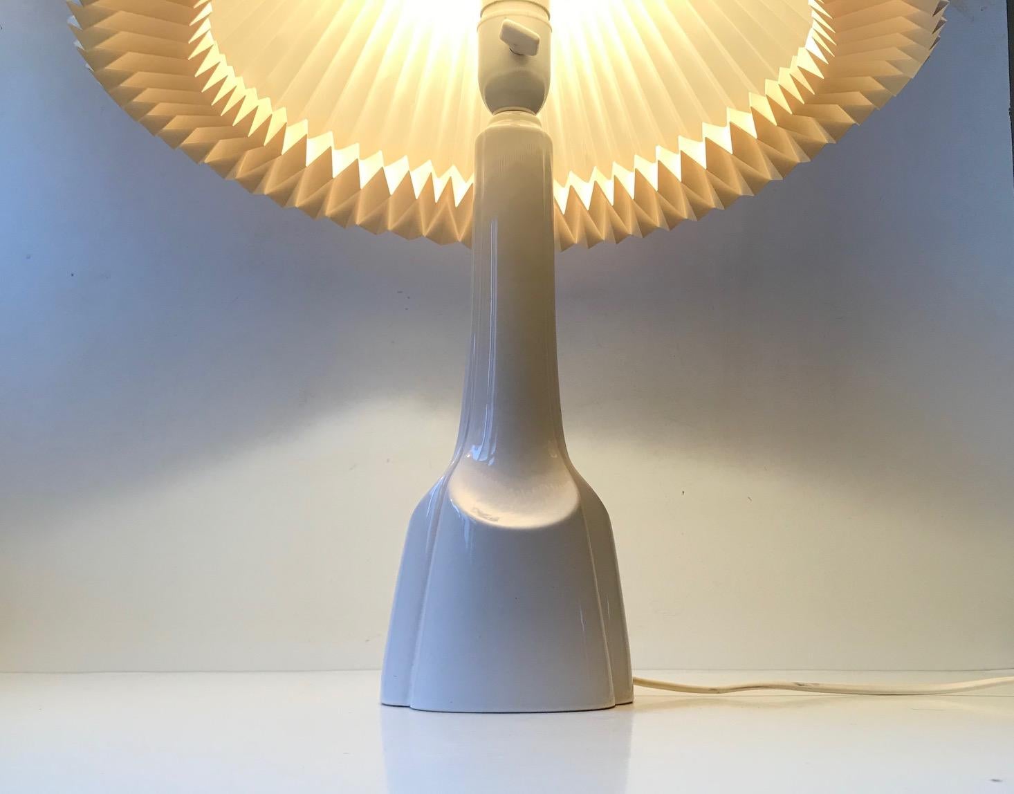 Danish pottery table lamp with a dens white glaze. Stylized architectural shape with soft balanced lines. This particular one was manufactured by Søholm in Denmark during the 1970s. It features its original socket with practical on/off switch.