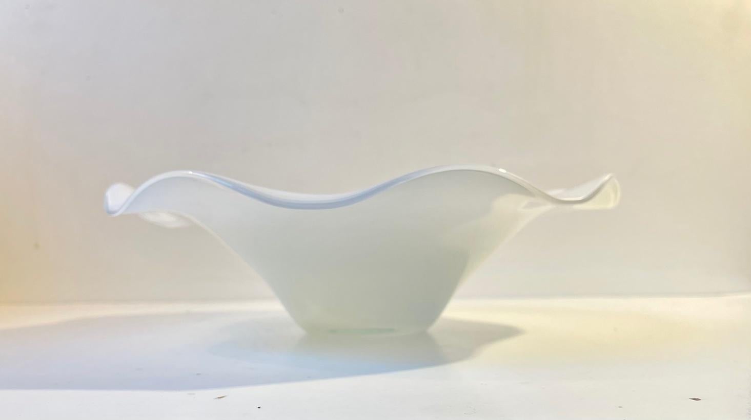 Freeform art glass centerpiece bowl listed as 'Art Glass No Name' in the Holmegaard catalogue. Its hand-blown and molded in a freely executed scalloped design. Its made from cased white opaline glass and it measures 30 cm in diameter and has a