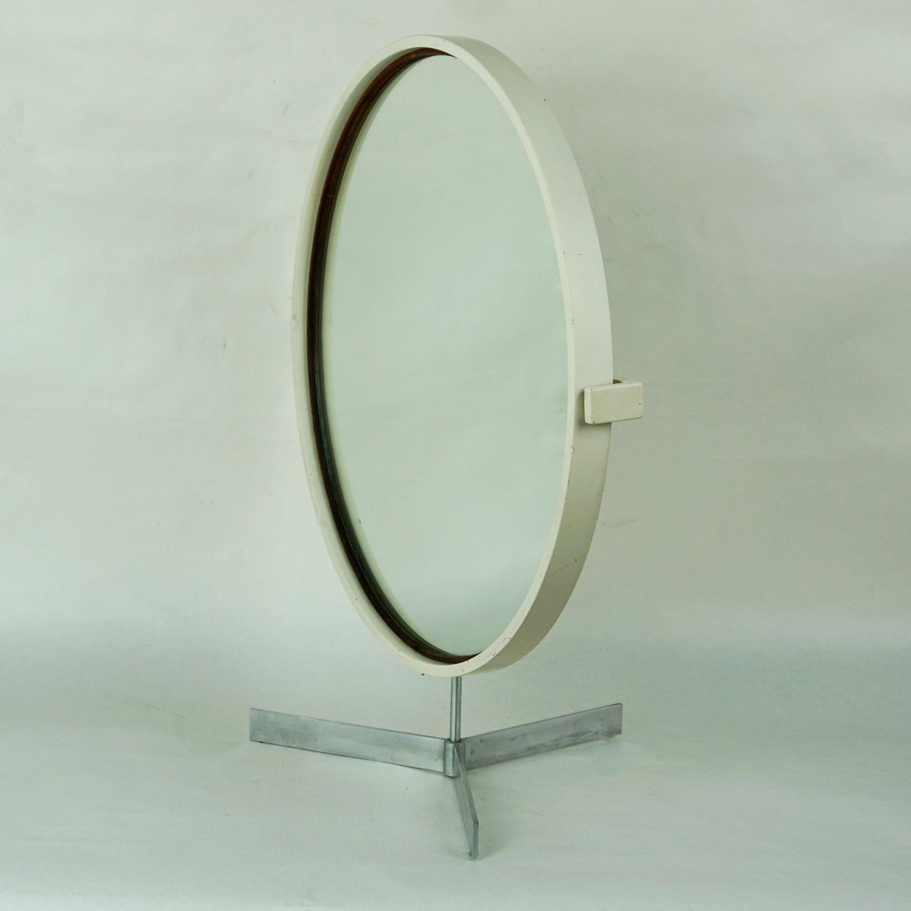 Amazing table mirror in white lacquered large version designed by Uno & Östen Kristiansson for LUXUS Sweden in the 1960s.
It features a Tripod stainless steel base with rotating wooden circular mirror. On the reverse it still has its original