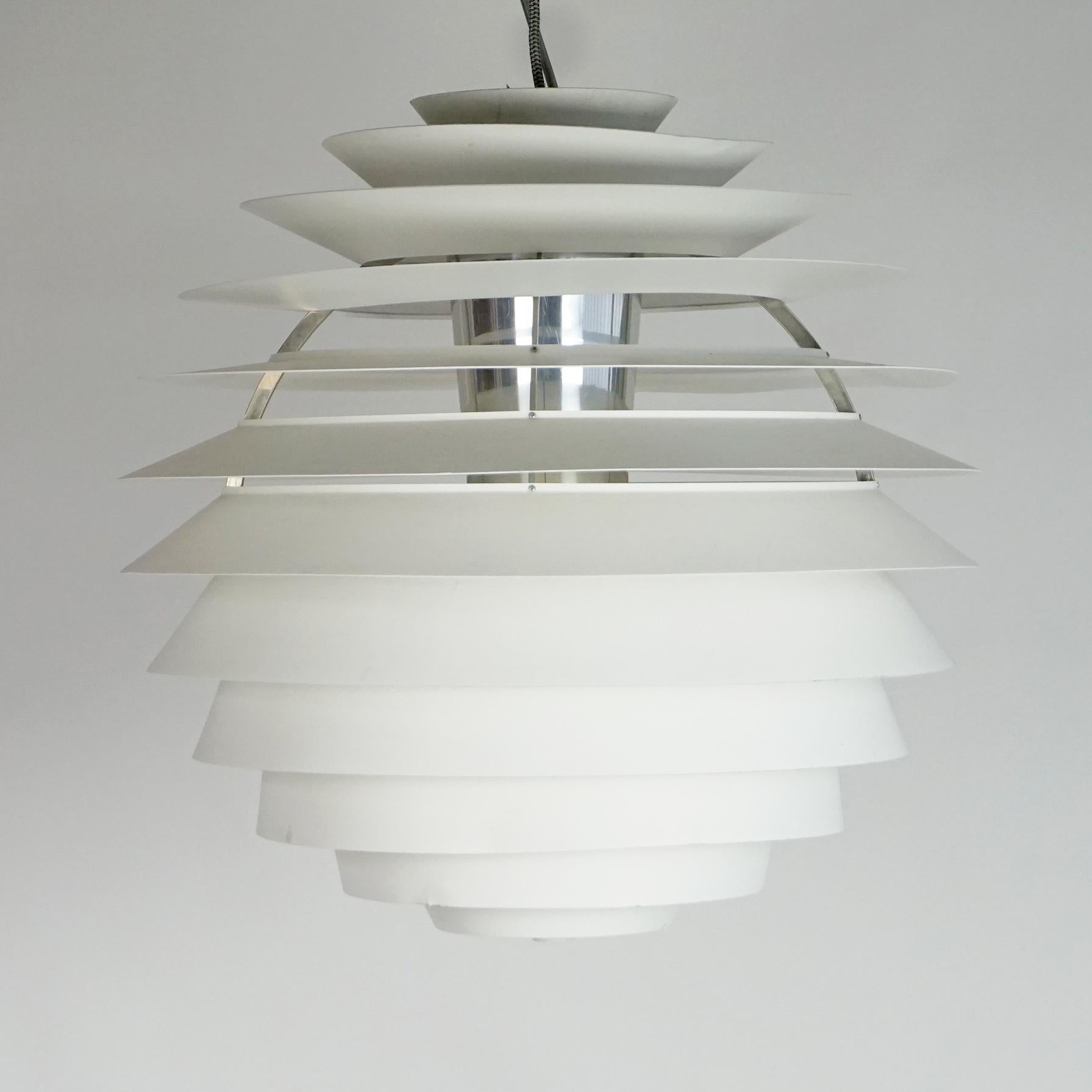 The PH Louvre was designed by Poul Henningsen 1958 and produced by Louis Poulsen.
This iconic fixture provides 100% glare-free light. Poul Henningsen developed the PH Louvre 1957 for a church in Skodsborg, Denmark.
It features 13 white lacquered