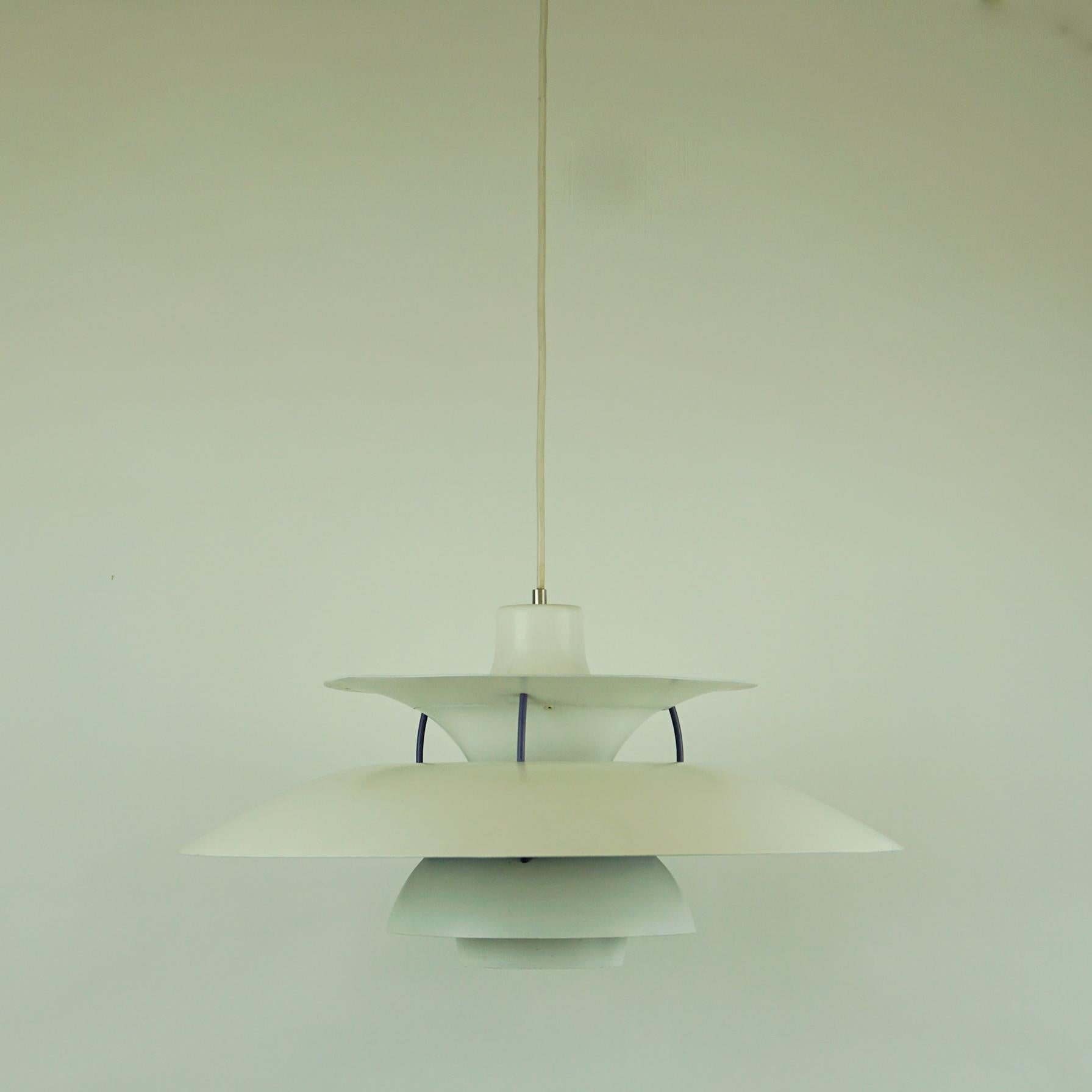 Ce luminaire emblématique fournit une lumière 100% non éblouissante. Poul Henningsen a mis au point le PH 5 en 1958 pour faire suite à son célèbre système à trois volets. Le luminaire émet une lumière à la fois descendante et latérale:: s'éclairant