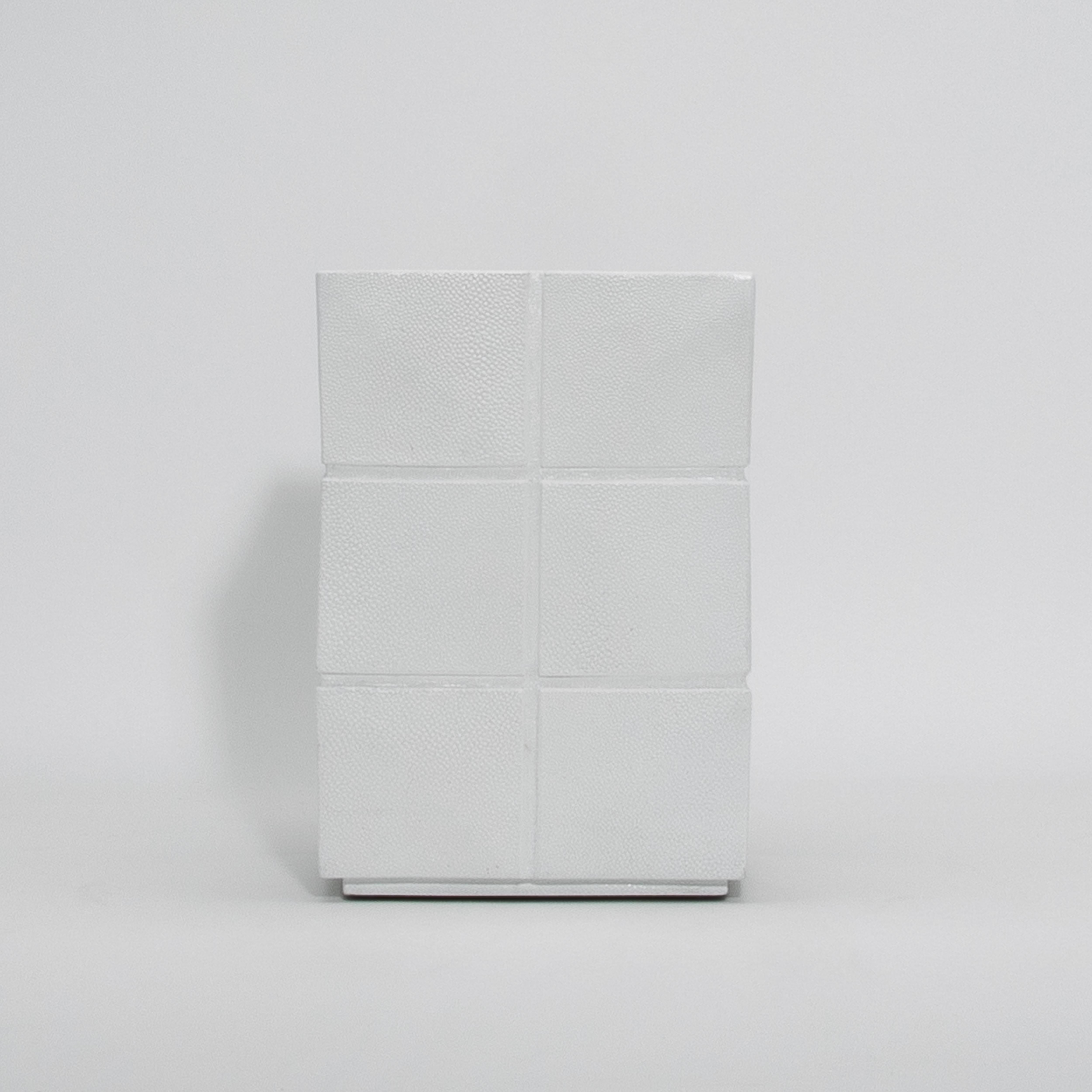 Il cestino romboidale White Shagreen di R&Y Augousti è un capolavoro di design funzionale, che combina materiali di lusso e artigianato. L'esterno è impreziosito da uno zigrino meticolosamente applicato a mano, che crea una superficie tattile con