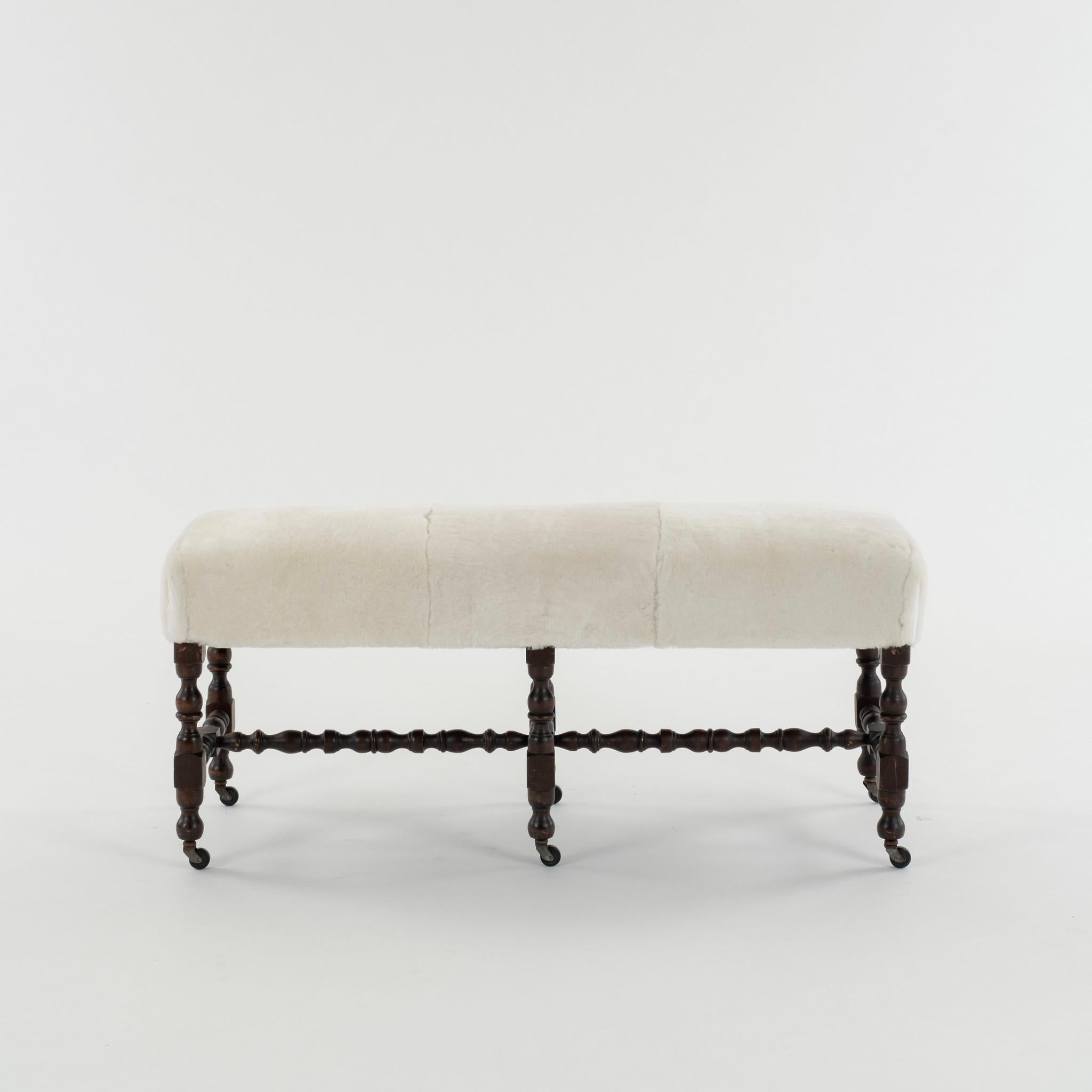 Flemish 19th century Louis XIII style hand carved bench on casters newly upholstered in a white sheepskin shearling.