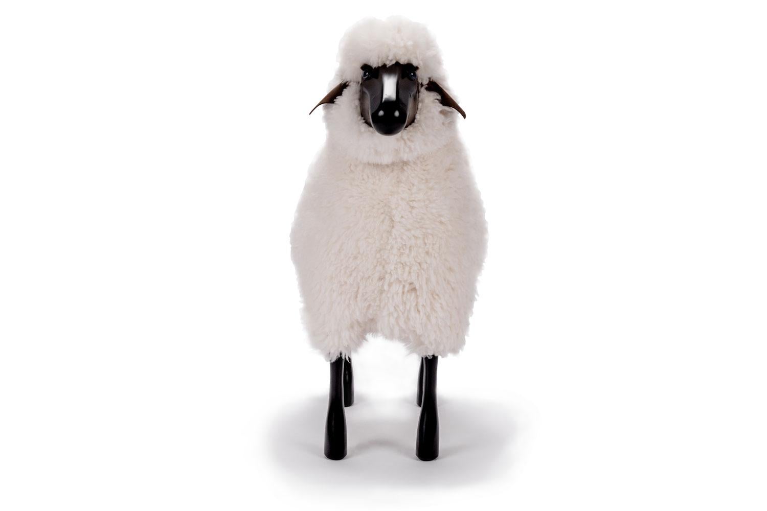 This life-size sheep with real sheepskin on black lacquered wood and brown colored leather ears is suitable as original seating or for decoration. Use as a stool - for example, around a dining table - the back of the sheep is extra heavily padded