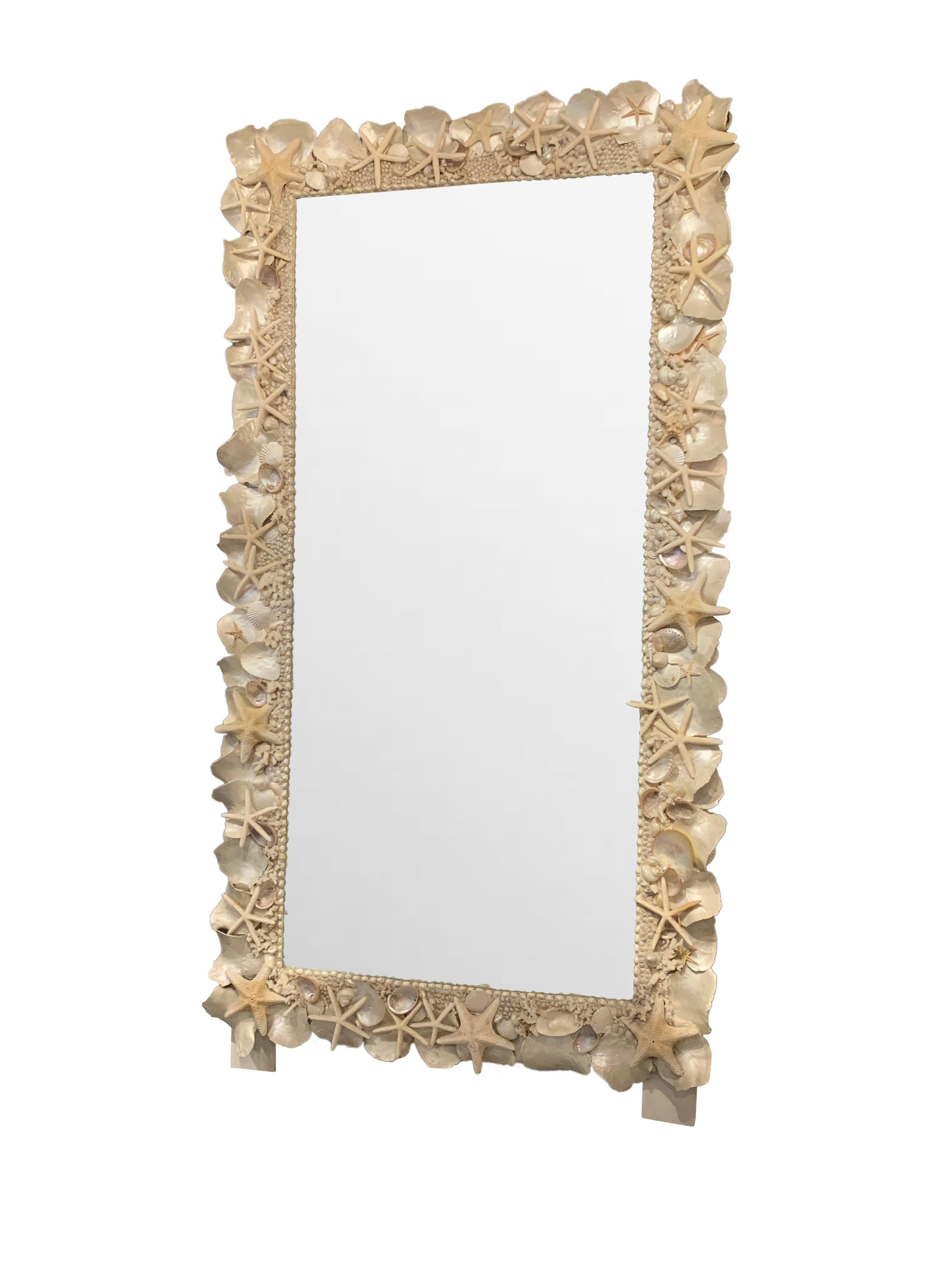 Exceptional Contemporary French extra extra large shell framed mirror.
A variety of shells are affixed to a wooden frame.
Wooden stands attached allowing the mirror to sit on the floor without damage to the shell frame.
Beveled mirror.
