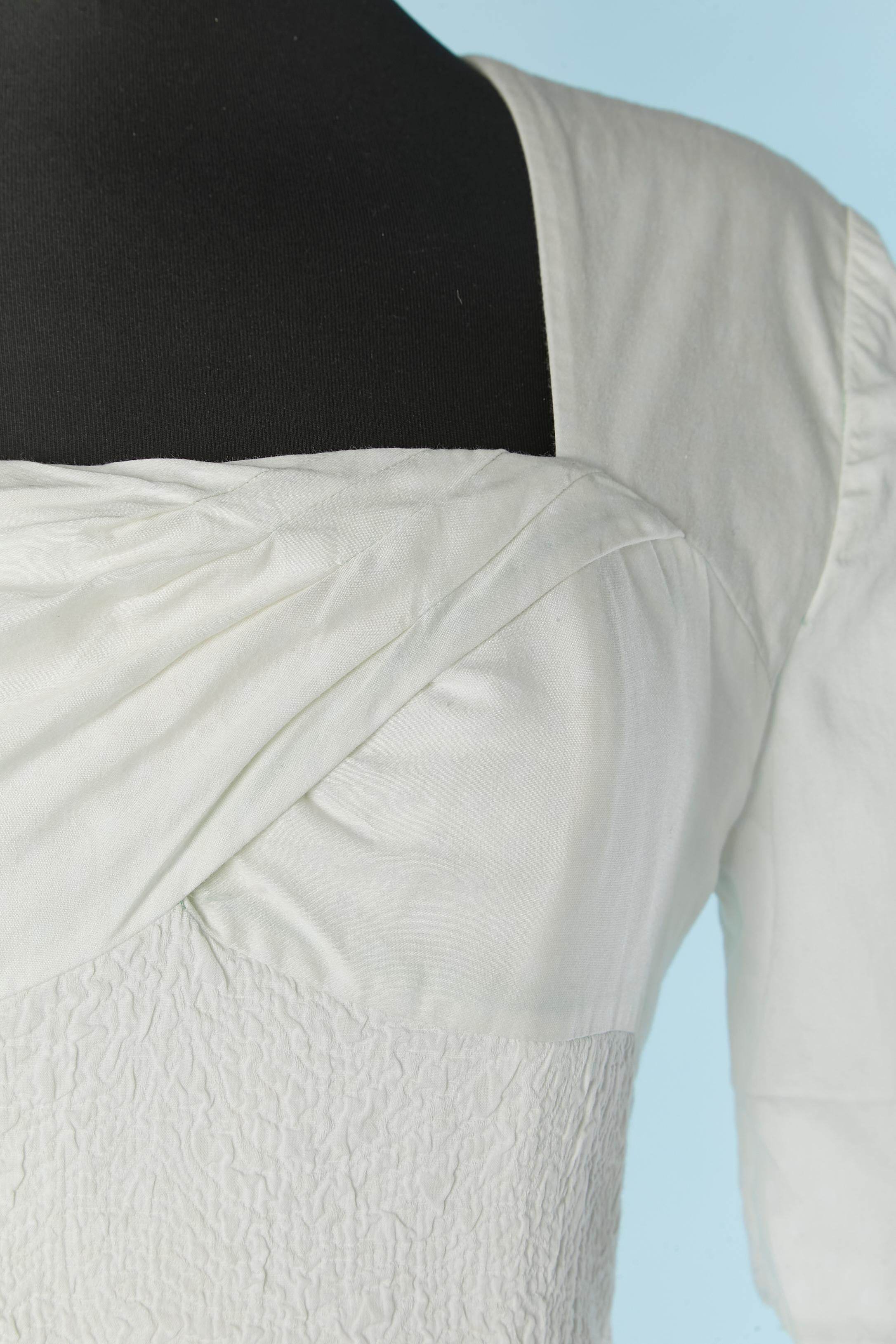 Robe blanche à manches courtes avec devant torsadé . Pas d'étiquette de composition du tissu, mais il s'agit probablement de coton mélangé à du stretch et la doublure est probablement en acétate ou en rayonne. Bustier désossé à l'intérieur avec