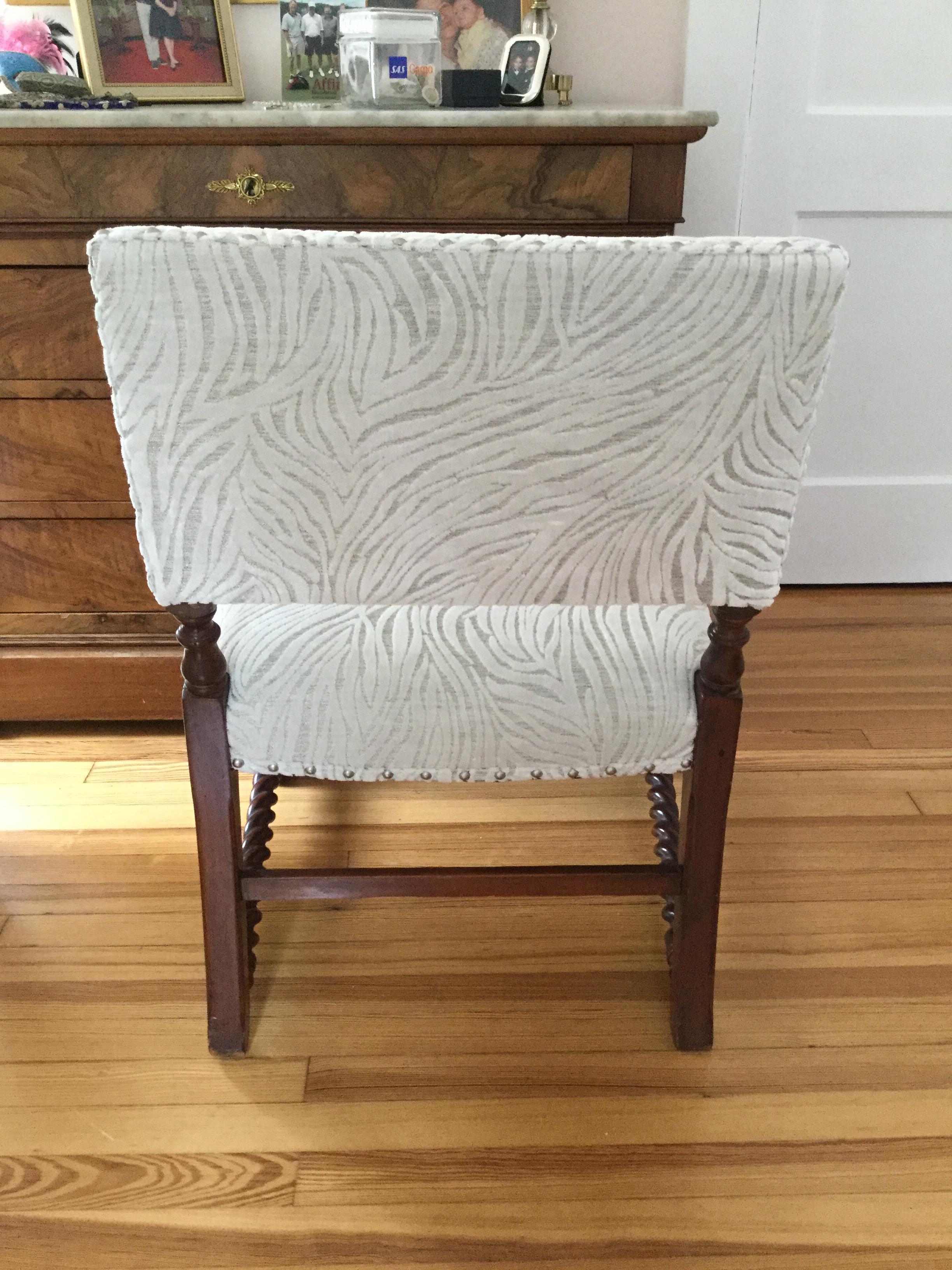 This antique English Barley-Twist chairs has been given a new look with a stunning white and silver thread velvet upholstery. The barley-twist turned legs and arms have a rich patina while the new upholstery is in perfect condition. Silver nailheads