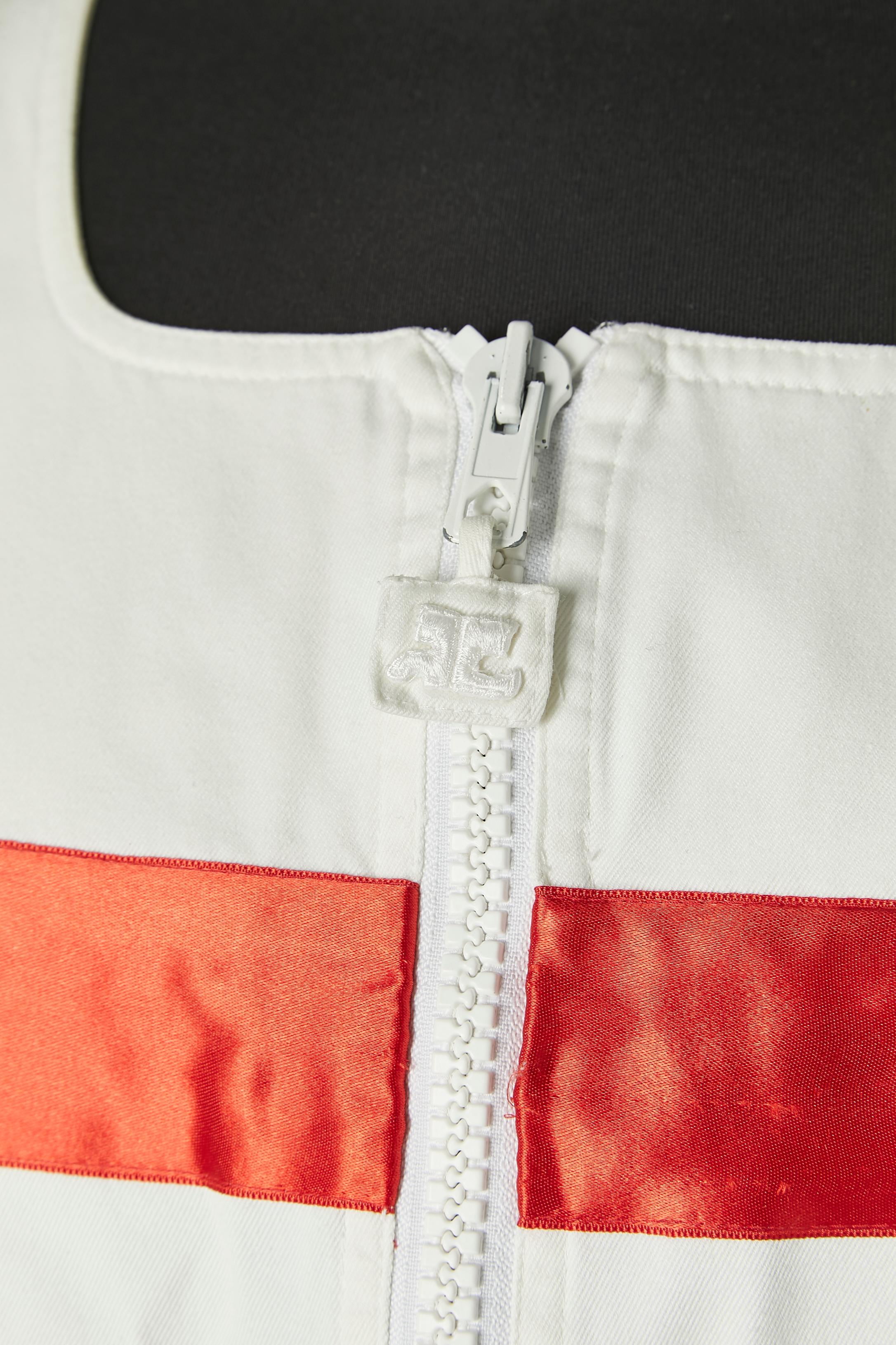 Abito bianco senza maniche in cotone con applicazioni di nastri di raso rossi. Chiusura con zip al centro della parte anteriore con tirazip del marchio. Tasca su entrambi i lati. 
SENZA ETICHETTA DI MARCA.
TAGLIA: 38 (Fr) / M 