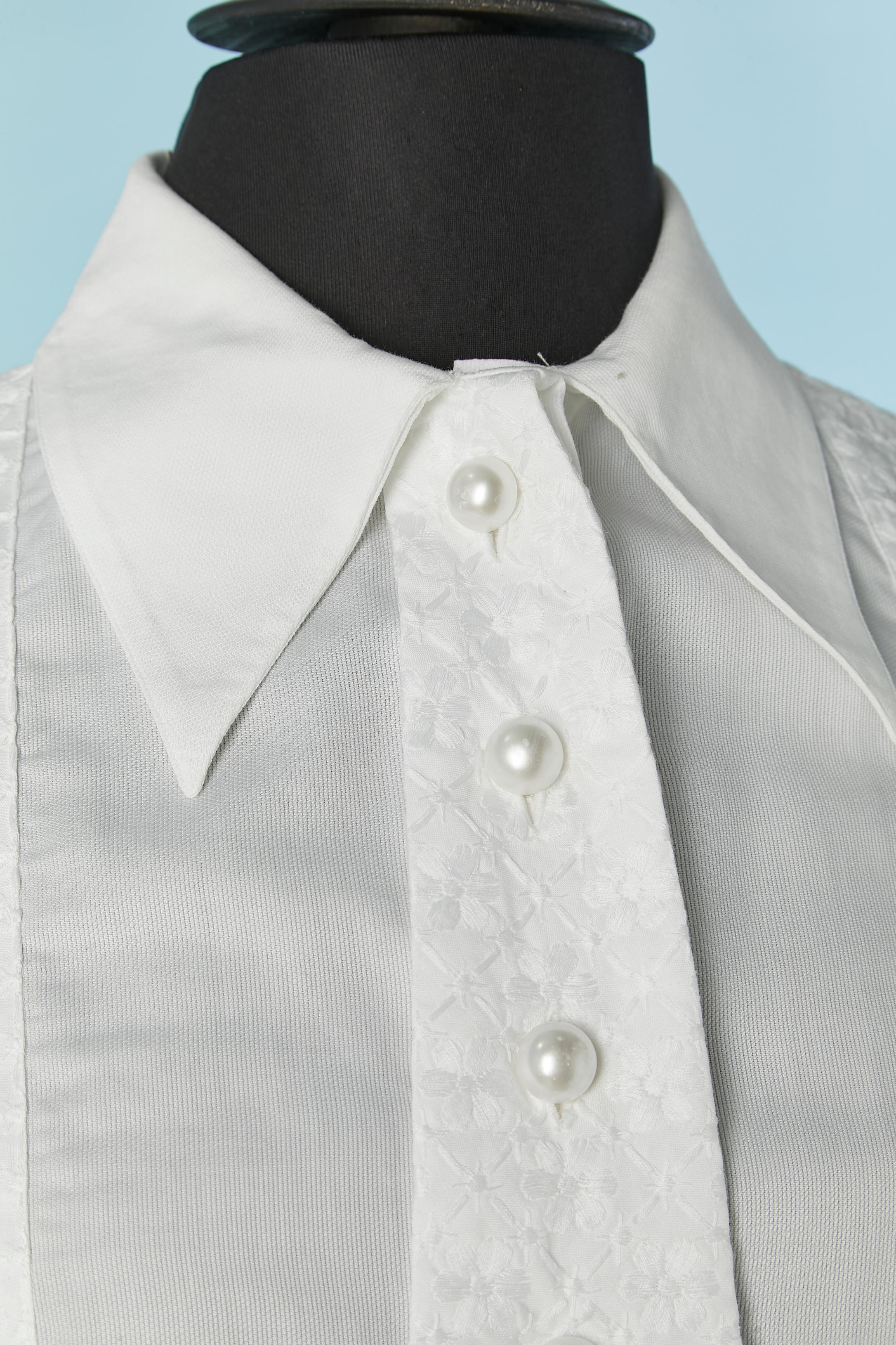White sleeveless shirt with tie and thread embroideries.  Perls button and buttonhole closure on the middle front. 
SIZE L 