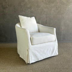 Chaise pivotante blanche recouverte de coussins en duvet