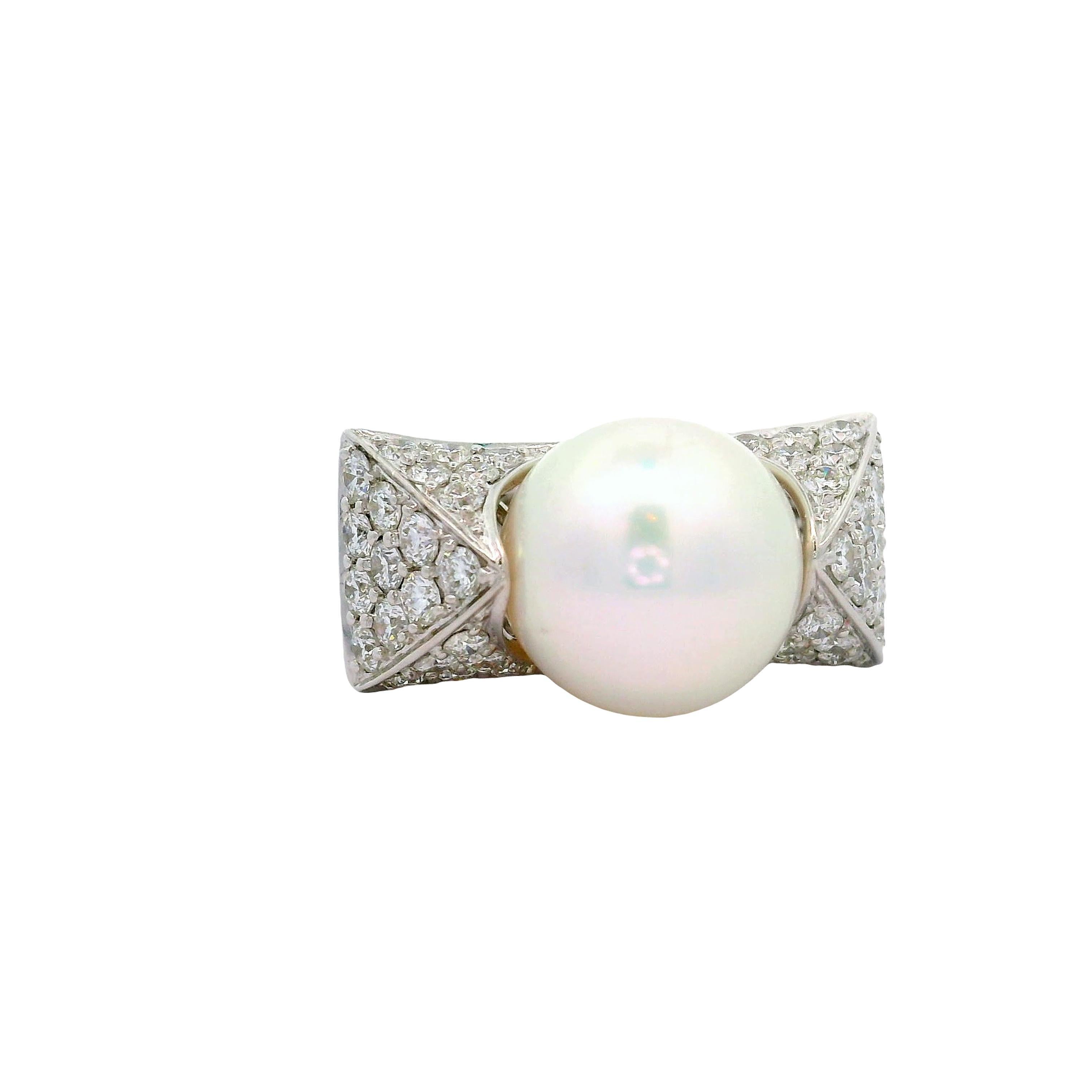 A striking South Sea Pearl, approximately 13.0 mm, takes center stage in this contemporary ring. The pearl's pristine white color exudes a timeless elegance. Surrounding the pearl are round diamonds, totaling 2.50 carats, adding a brilliant sparkle