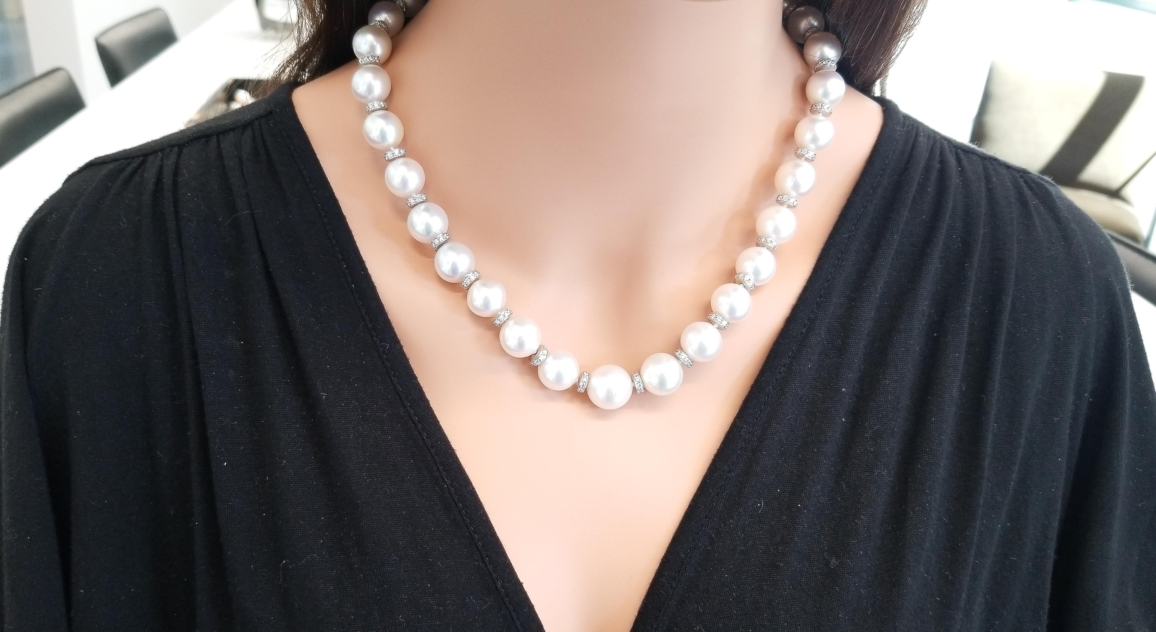 This large, sophisticated strand of pearls features white South Sea pearls that are an exotic luxury. This necklace features 12-14 millimeter South Sea pearls, perfectly ivory white color matched. Dazzling diamond roundels are stationed between each