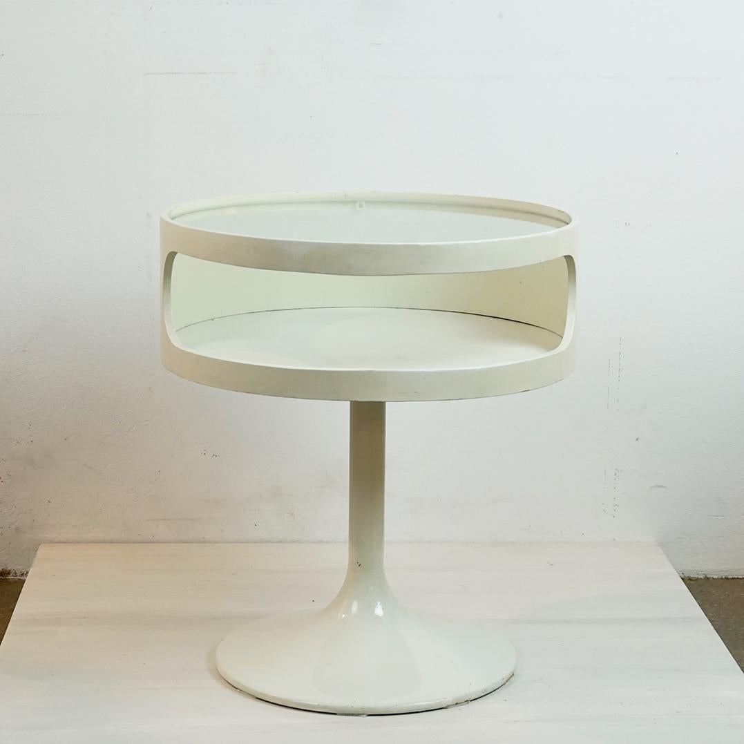 Dieser charmante, weiß lackierte, runde Space Age Beistelltisch mit Metalltulpenfuß und Glasplatte wurde in den 1960er Jahren in Deutschland hergestellt. Es ist in sehr schönem  Zustand und weist noch das originale Label des Herstellers auf der