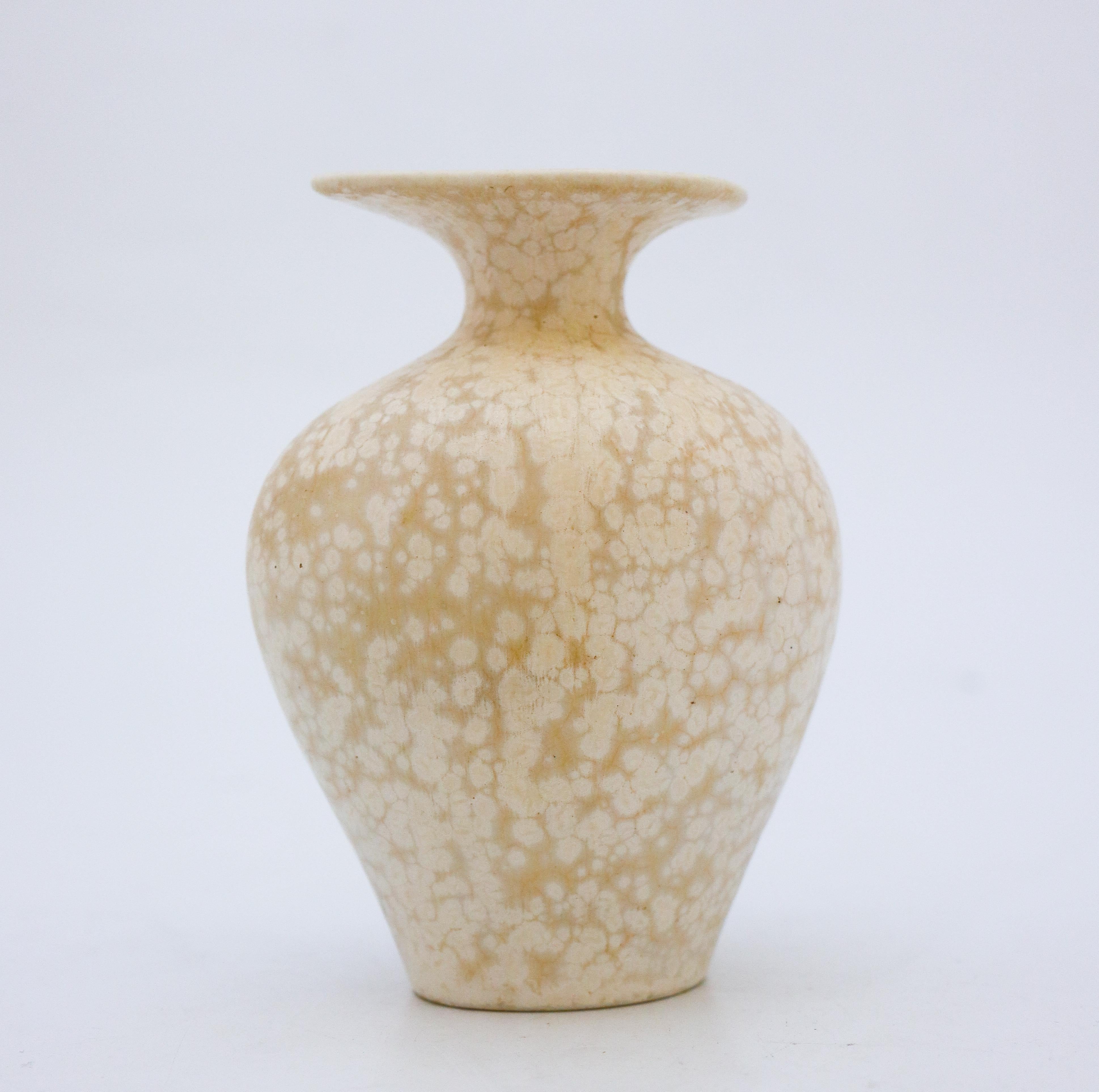 Eine Vase mit einer schönen weiß/creme gesprenkelten Glasur, entworfen von Gunnar Nylund in Rörstrand. Sie ist 12,5 cm (5) hoch. Sie ist in sehr gutem Zustand, abgesehen von einigen kleinen Flecken in der Glasur. 

Gunnar Nylund wurde 1904 in