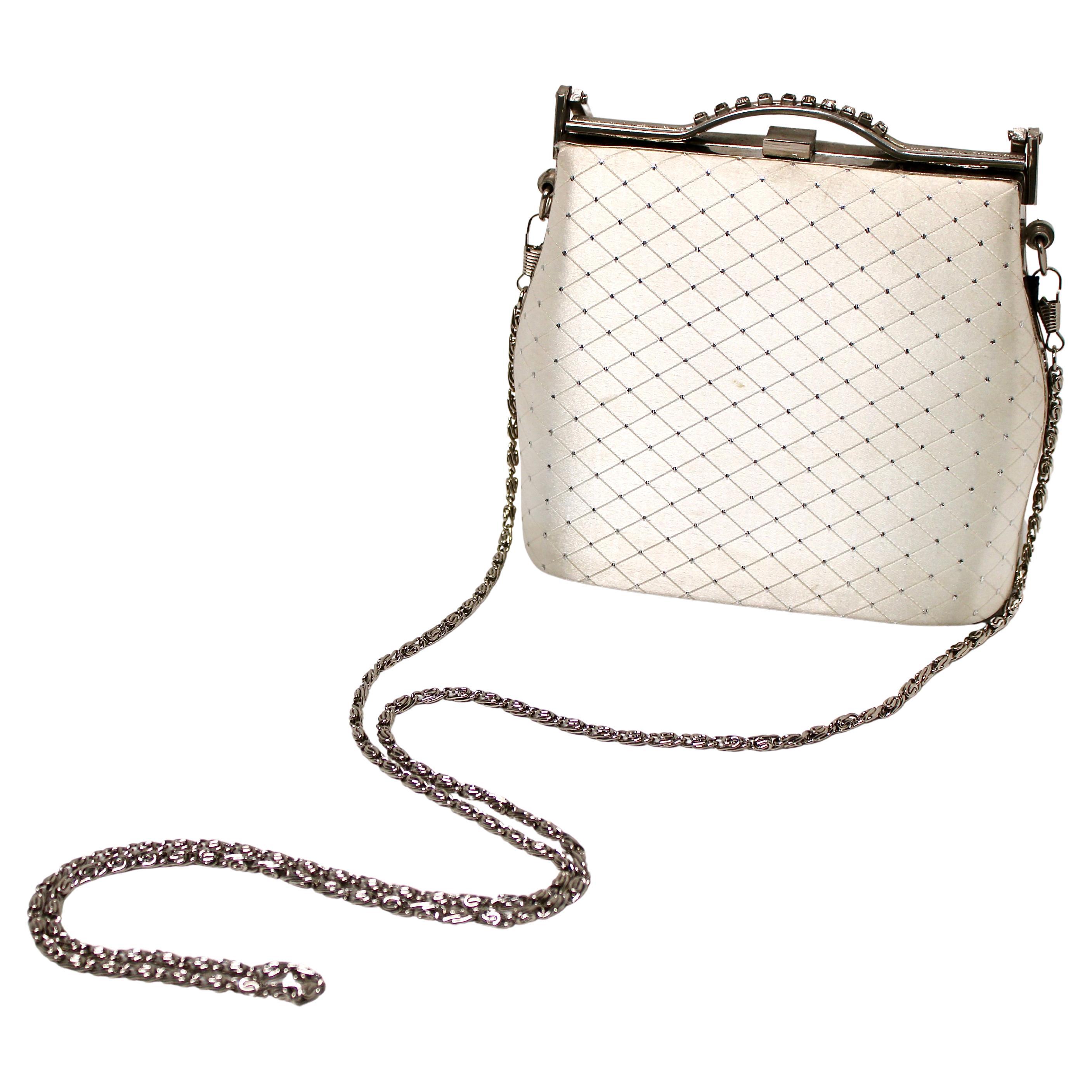 Cet élégant sac de soirée matelassé avec chaîne, datant des années 1960, dégage une sophistication intemporelle et un charme vintage. Fabriqué avec une attention méticuleuse aux détails, le sac présente un extérieur matelassé accentué par une