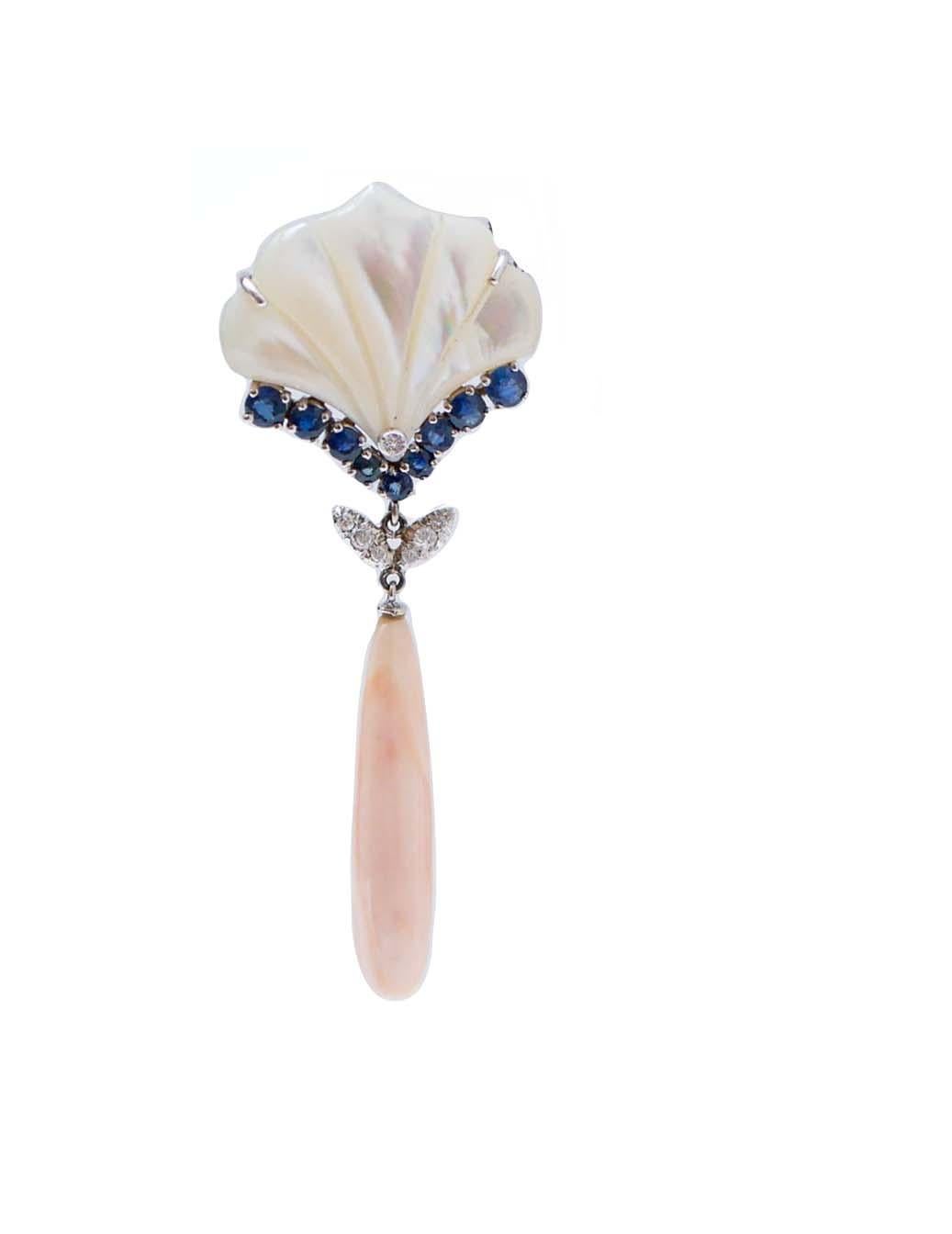 Incredibili orecchini con struttura in oro bianco 14 kt montati con un ventaglio di pietre bianche e un diamante. Al centro, zaffiri e foglie tempestate di diamanti e, come pendente, un corallo.
Questi orecchini sono stati realizzati totalmente a