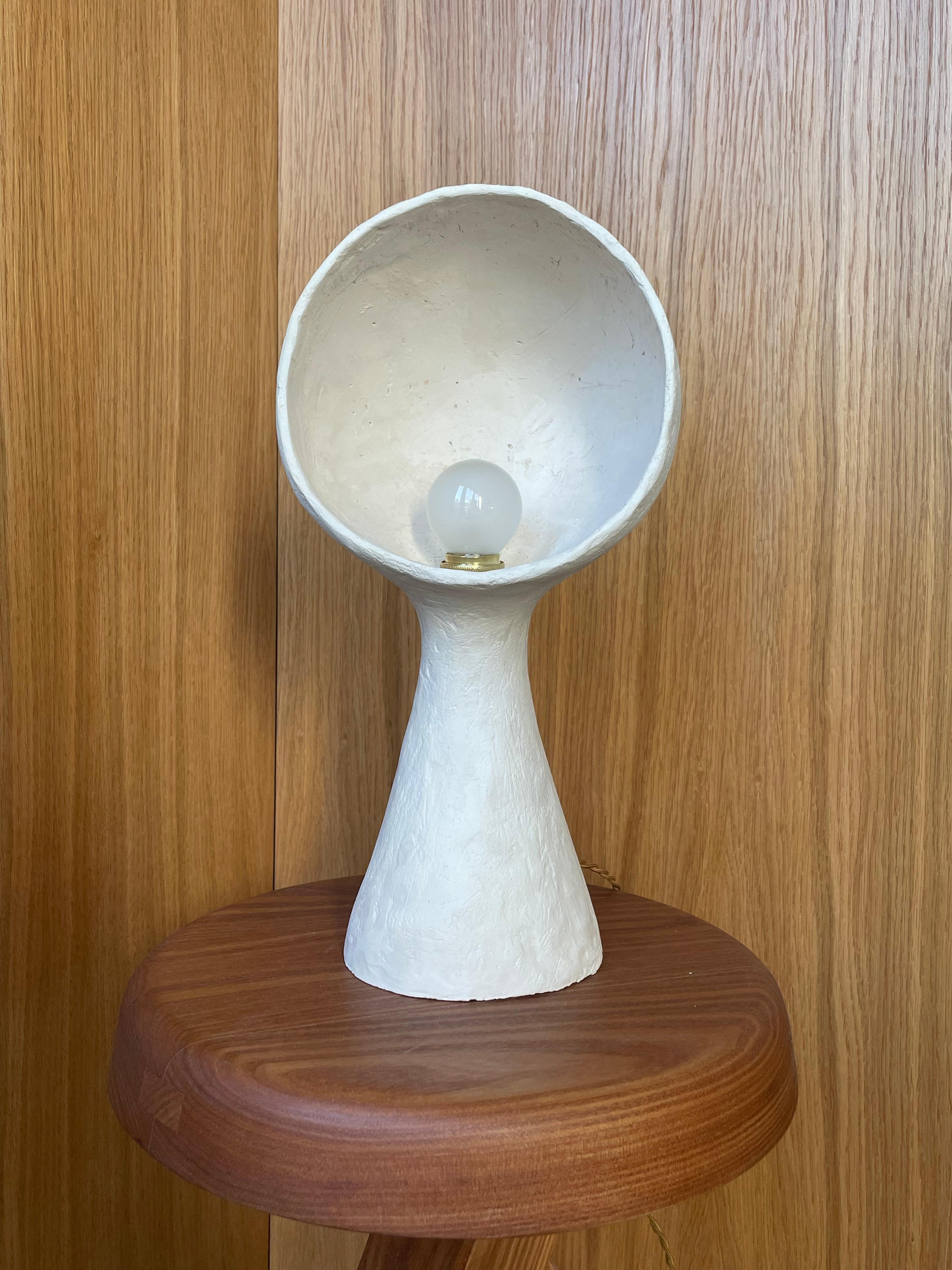 White Stoneware Lamp Ninfea by Renzo Maar
Dimensions:  W 18 x D 11 x H 36 cm
Materials: Ceramic (white stoneware), Signed.

Made from criss-cross scratched clay, this lamp-sculpture looks something like an old car headlamp, an antique dummy head or