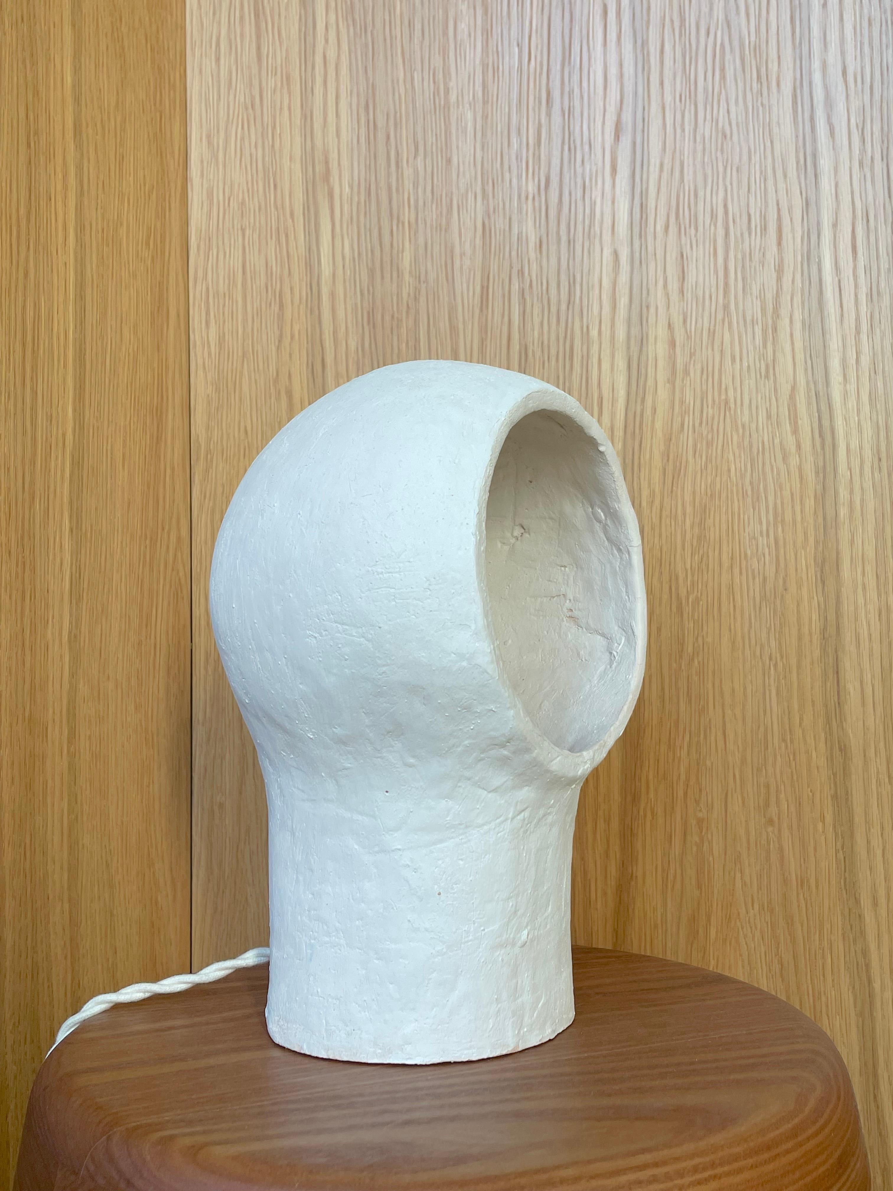 Lampe aus weißem Steingut Nuvole 1 von Renzo Maar
Abmessungen:  B 18 x T 15 x H 26,5 cm
MATERIALIEN: Keramik (weißes Steingut), Signiert.

Diese Lampen-Skulptur aus kreuz und quer gekratztem Ton sieht aus wie eine Wolke, ein Nest oder ein