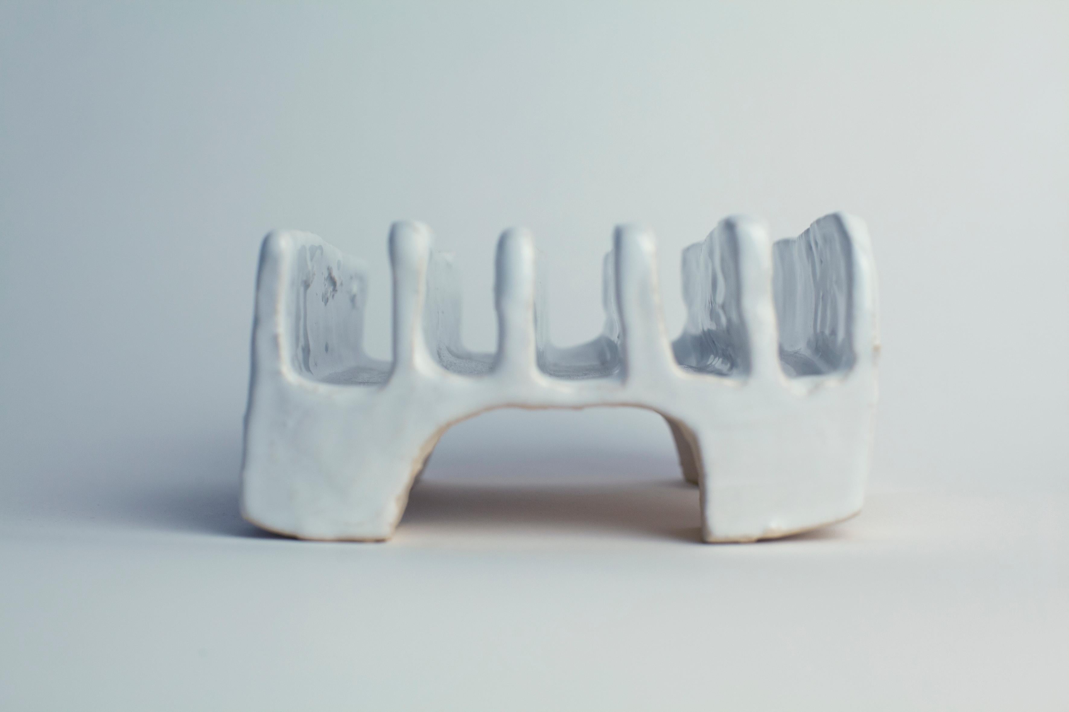 A unique, white object made by Danish Artist Christine Roland.
Hand- build from white stoneware with a white, glossy glaze. 
This playfully shaped piece lends its form from the classic toast rack and can serve both as a decorative object or a