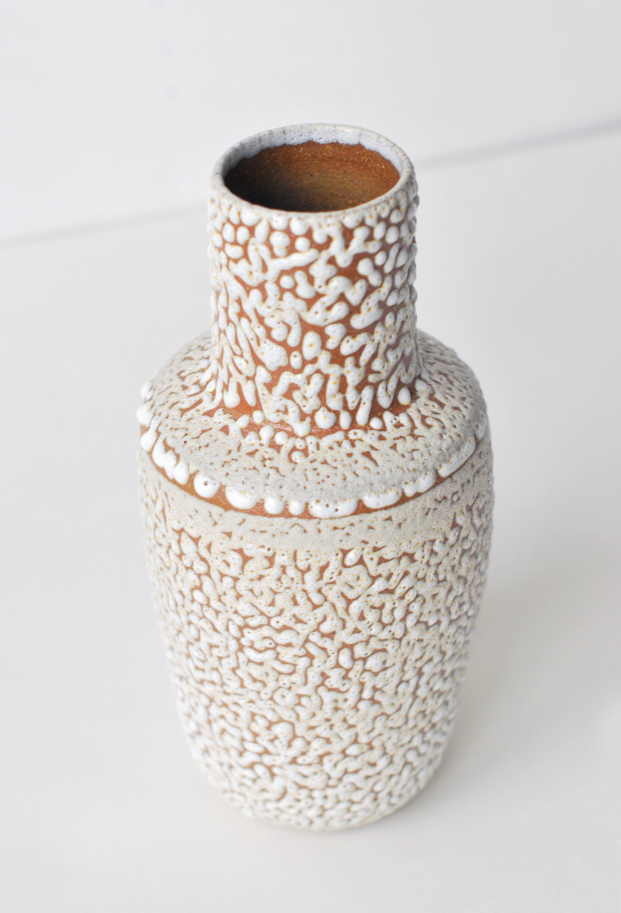 White stoneware vase by Moïo Studio
Dimensions: 17 x 7 x 7 cm
Materials: White crawl glaze on tan stoneware

Is the Berlin-based ceramic art studio of French-Palestinian artist Maia Beyrouti. It was created in 2016 as a result of the desire to