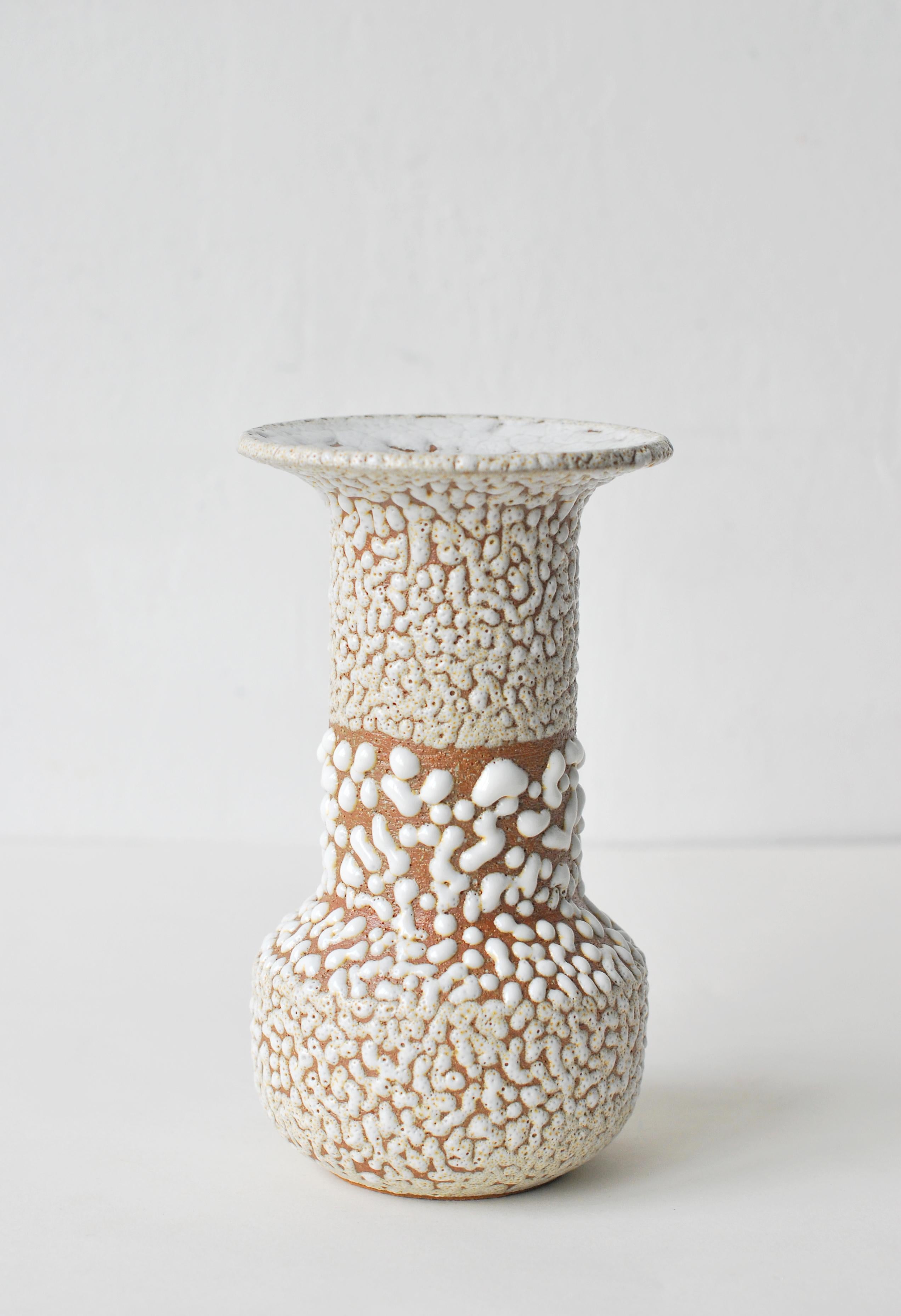 White stoneware vase by Moïo Studio
Dimensions: 16 x 6 x 6 cm
Materials: White crawl glaze on tan stoneware

Is the Berlin-based ceramic art studio of French-Palestinian artist Maia Beyrouti. It was created in 2016 as a result of the desire to