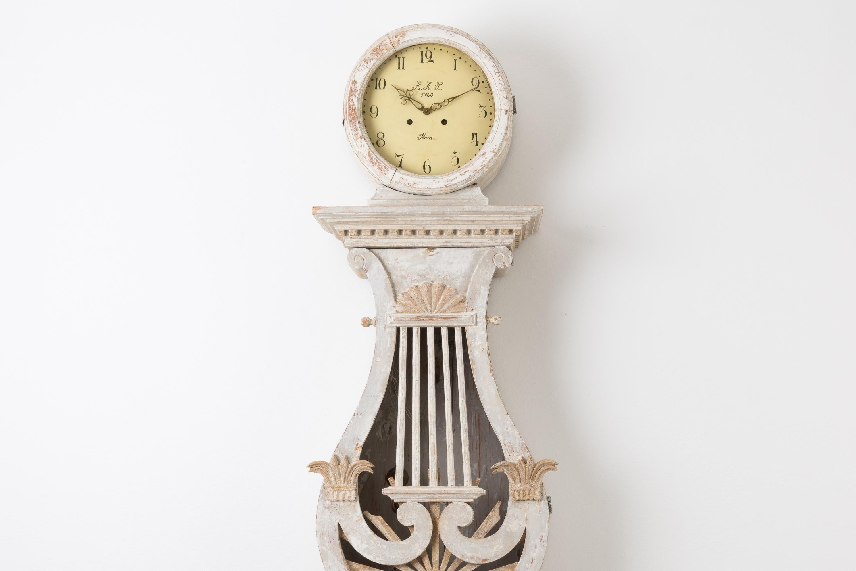 Swedish Empire long case clock from the early 1800s. The clock is made between 1820 and 1840 in pine with old distressed paint. The model is rare with a cutout design on the door. The clock comes with the original mechanism, weights and pendulum.